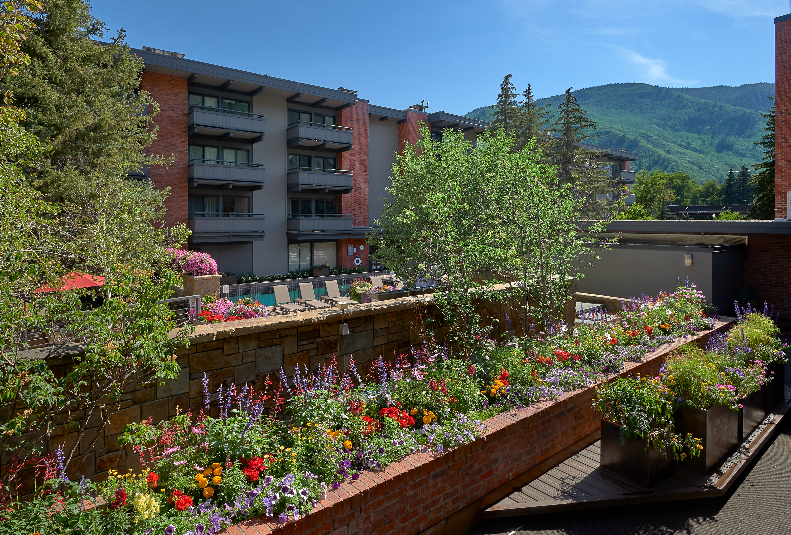 Scenic mountain-view courtyard with vibrant gardens and private balconies