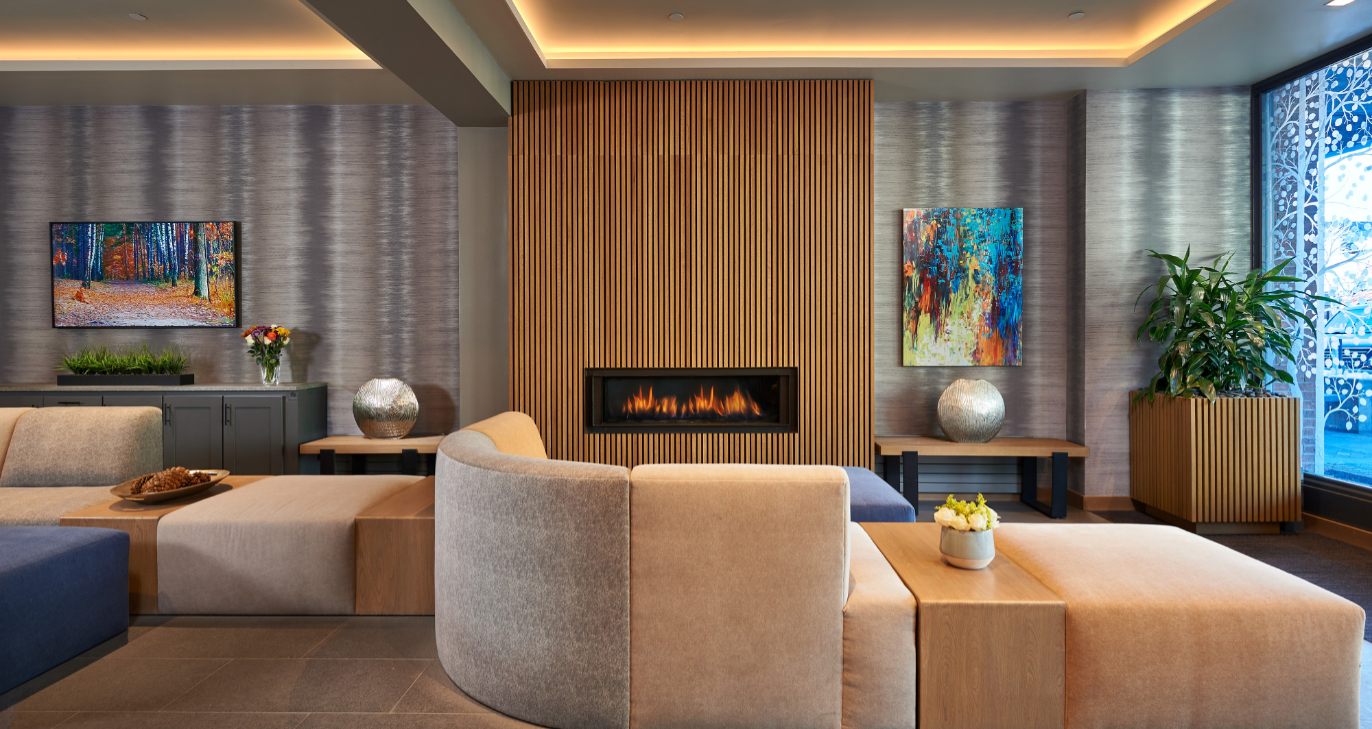 Elegant modern lounge with fireplace, plush seating, and warm designer touches