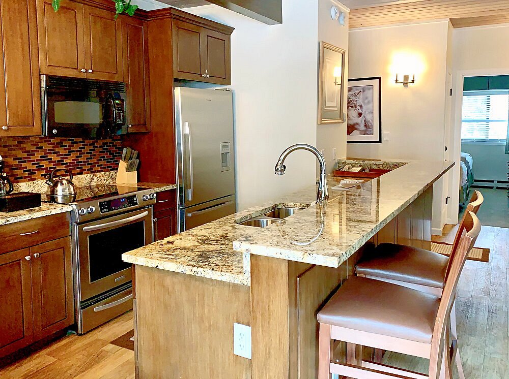 Granite island kitchen with bar seating and stainless steel appliances