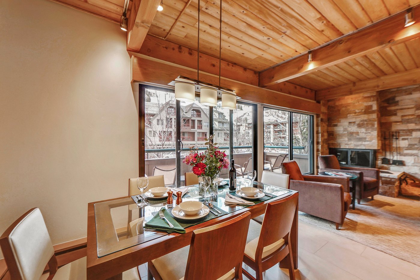 Warm mountain-style dining and living space with fireplace views