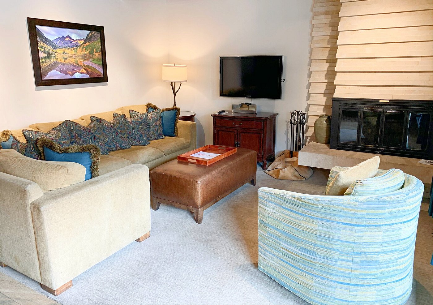 Cozy living room with fireplace, plush seating, and TV