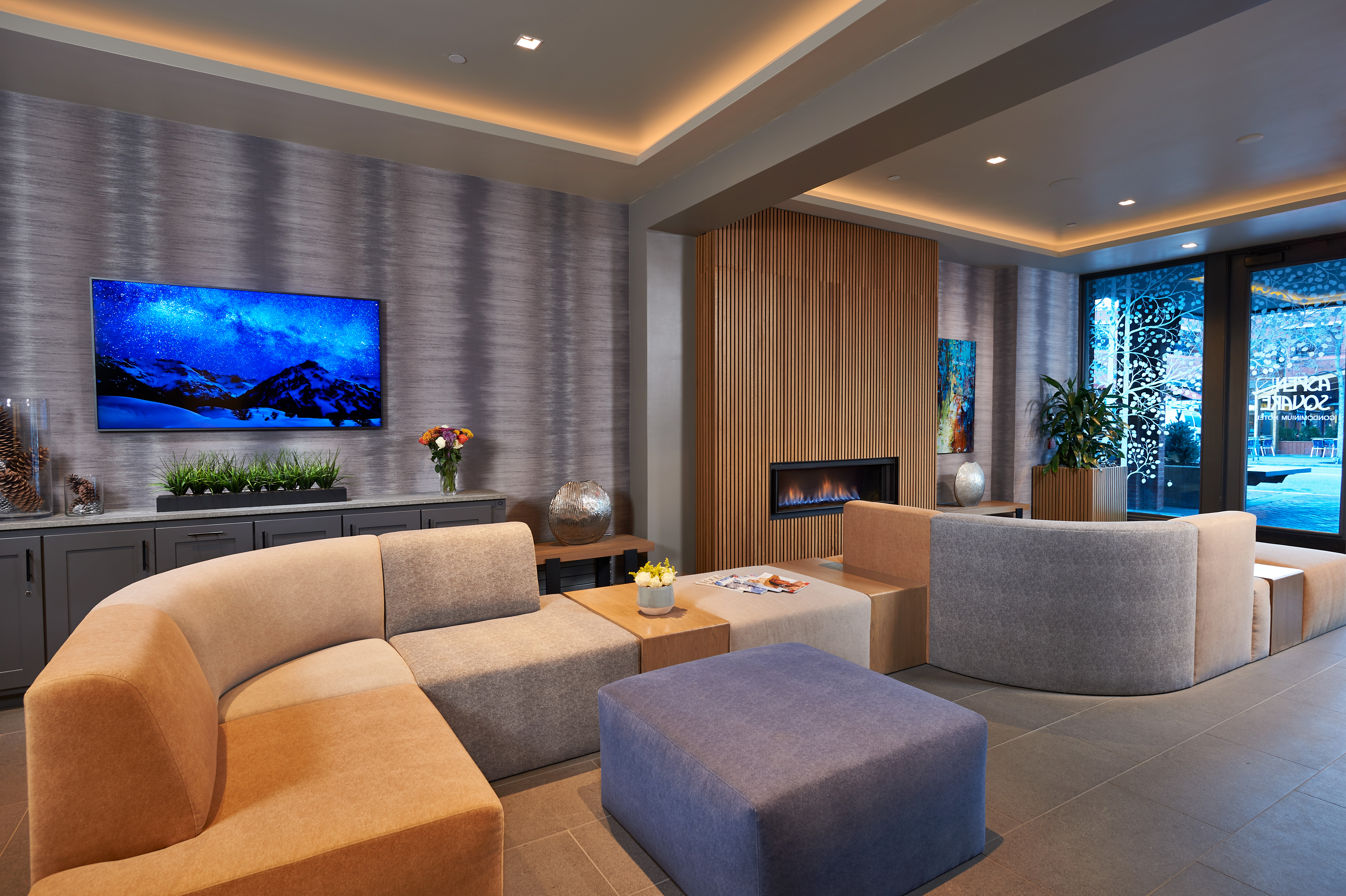 Upscale modern lounge with cozy fireplace, designer seating, and warm lighting