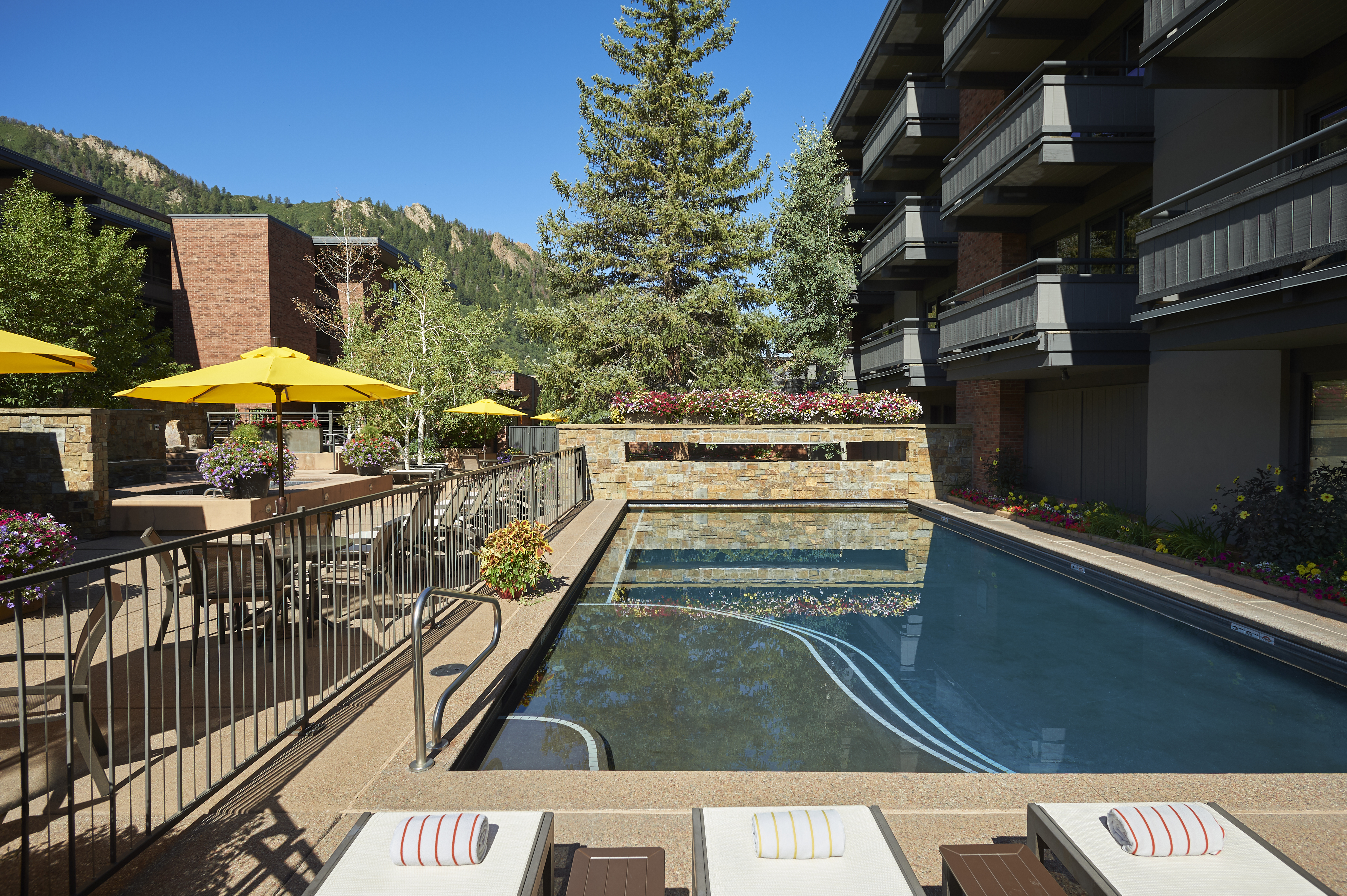 Resort-style outdoor pool with mountain views and sunny lounge deck