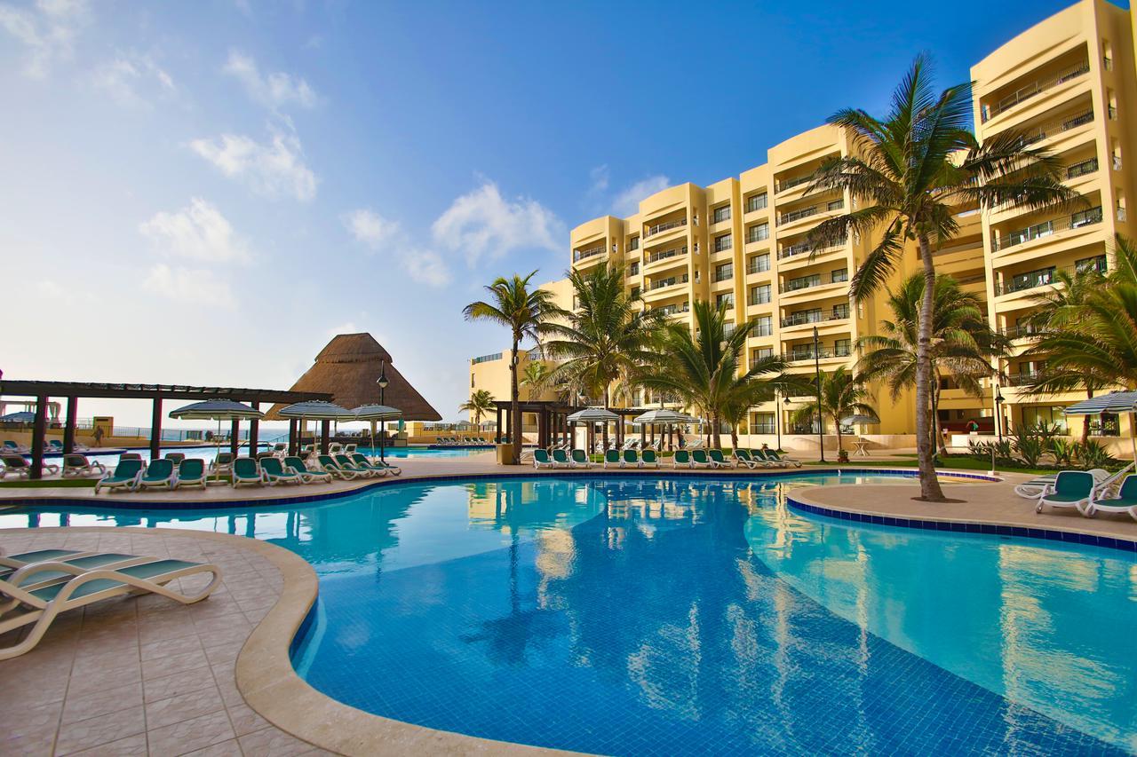 Resort-style pool with palm trees, loungers, and tropical beachfront vibes