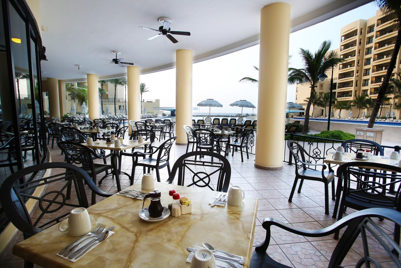 Open-air resort dining terrace with poolside and palm-lined views