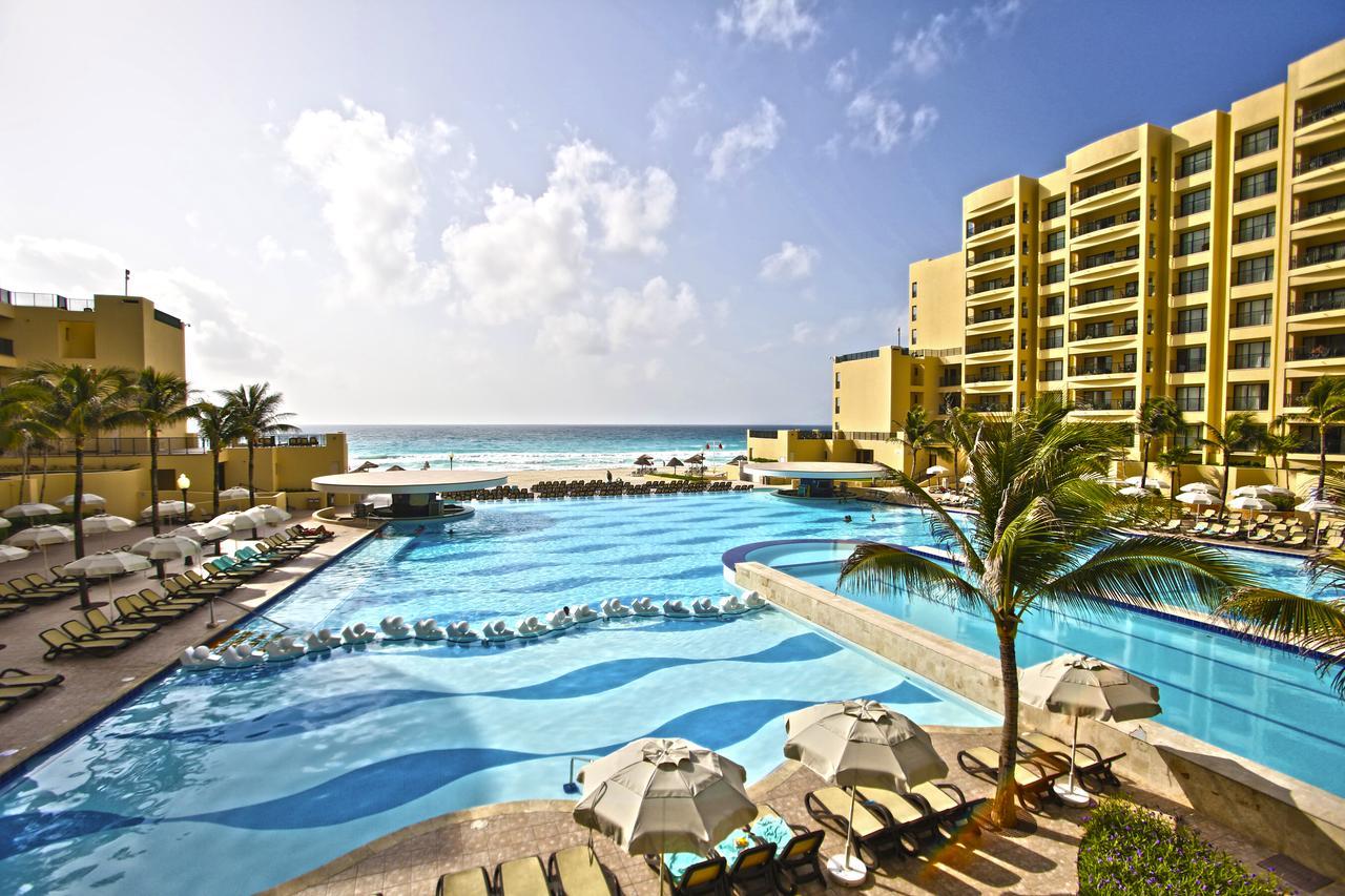 Expansive oceanfront pool with beach views, palms, and resort-style lounging