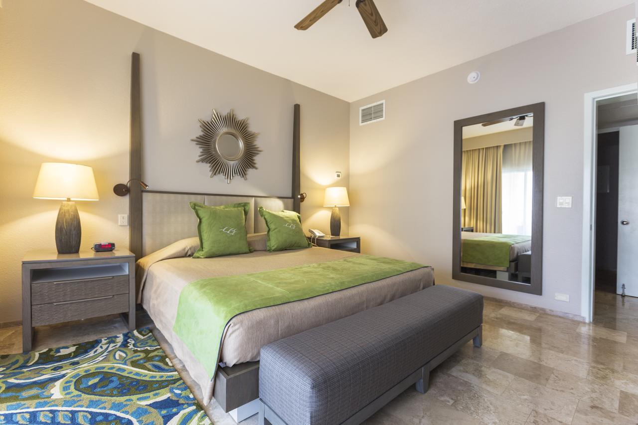Elegant king bedroom with canopy bed, bench seating, and warm lighting