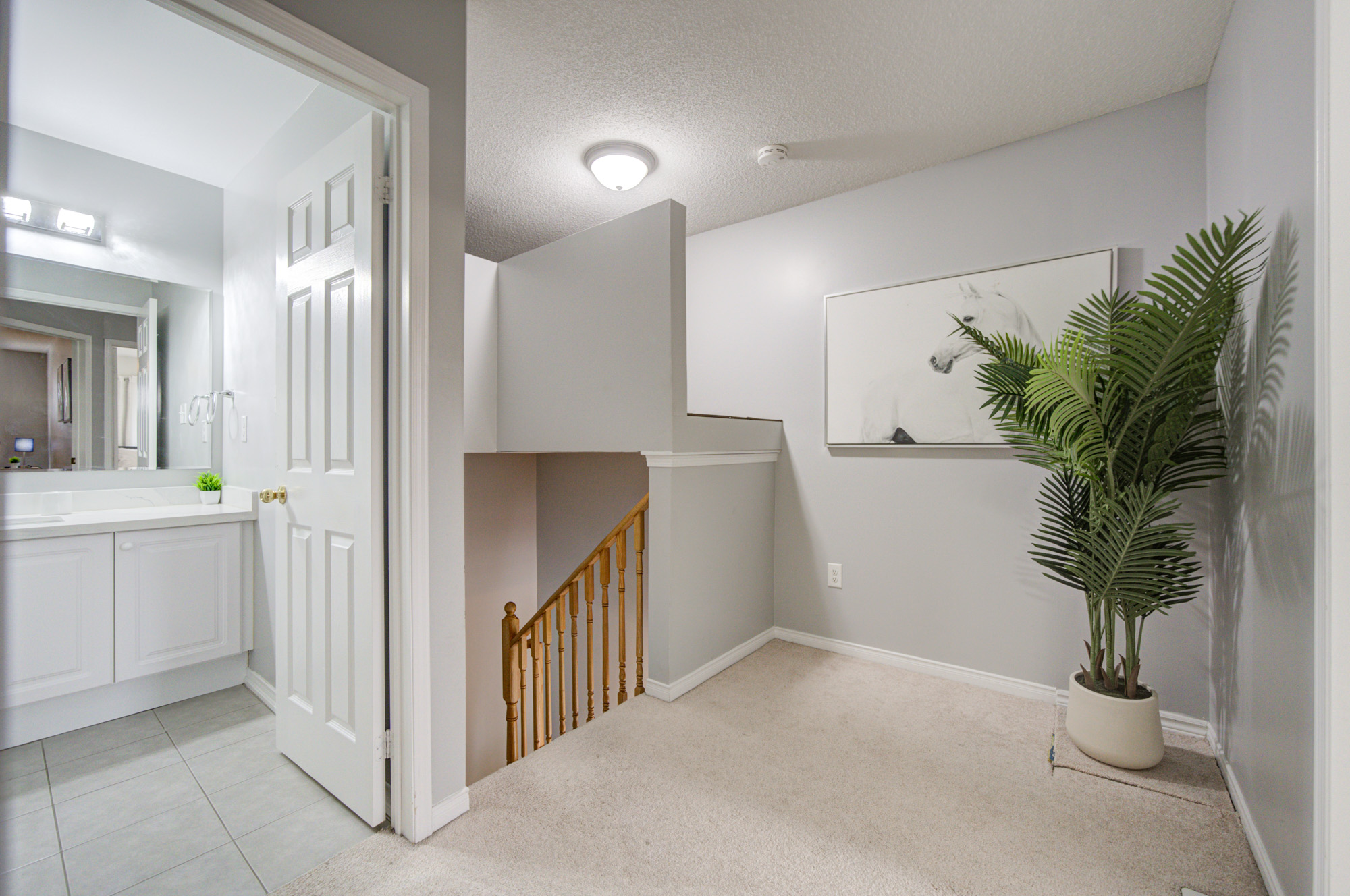 Bright upper landing with nearby bath and clean, modern styling