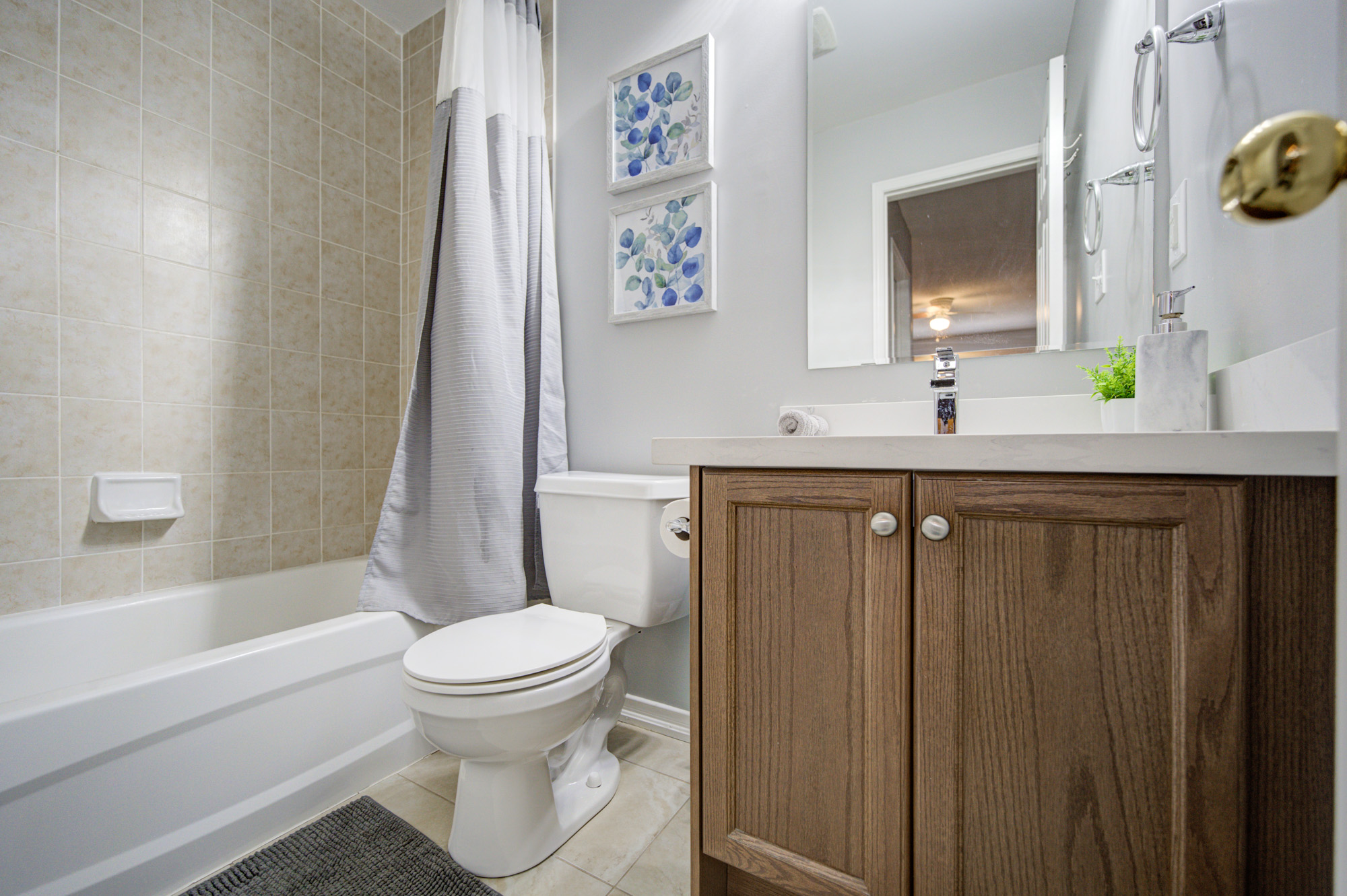 Bright full bathroom with tub-shower combo and modern vanity