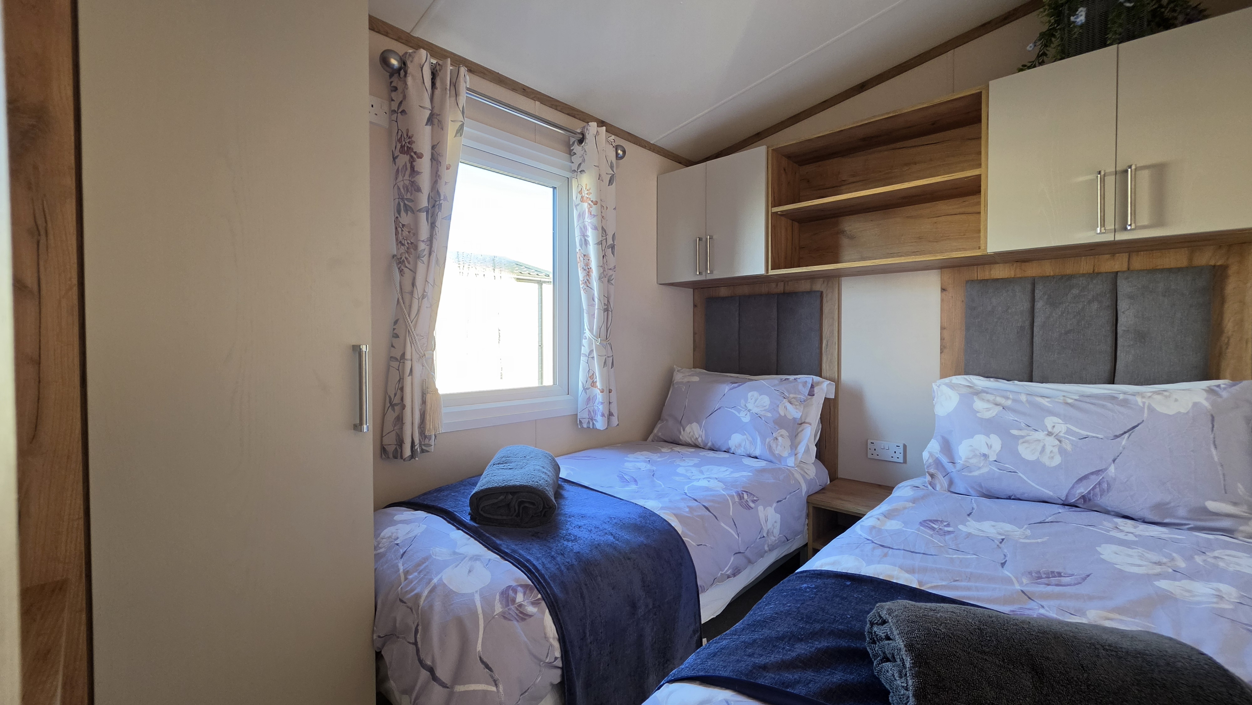 Bright twin bedroom with built-in storage and cozy, inviting bedding