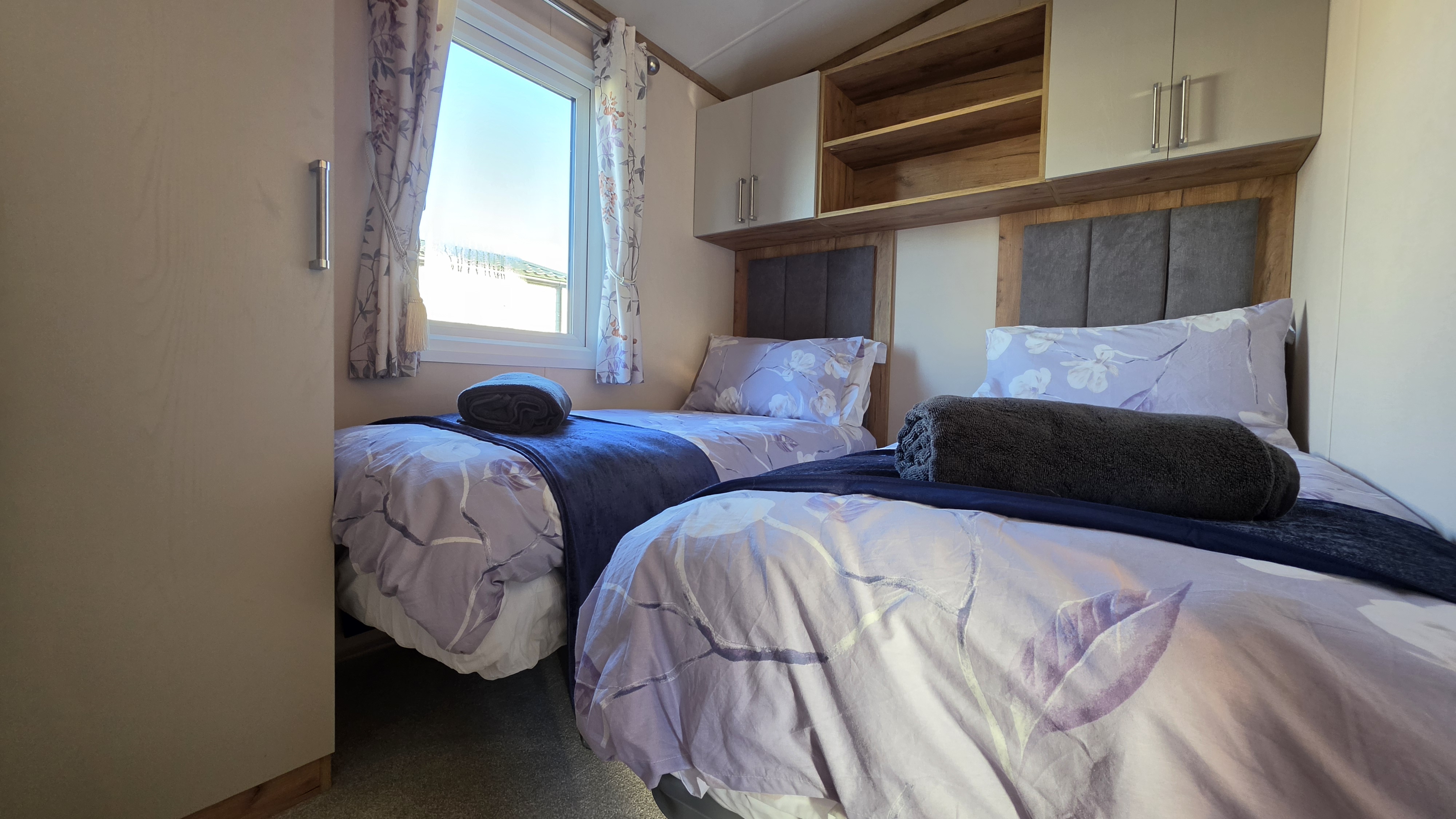 Bright twin bedroom with built-in storage and fresh, cozy styling