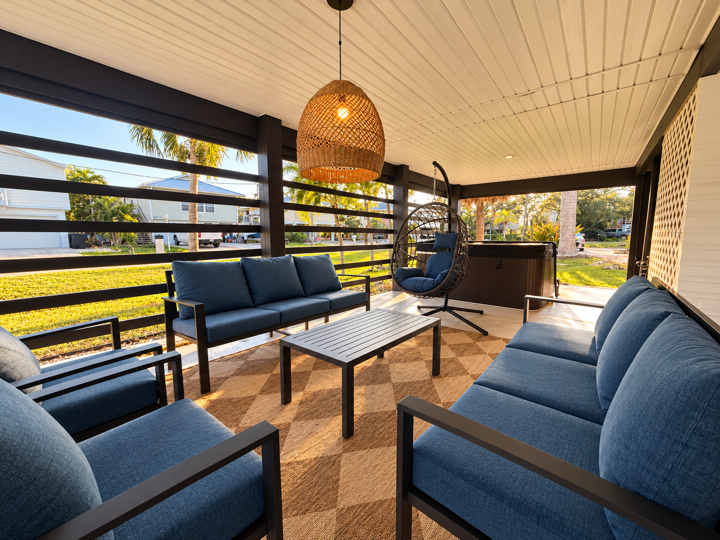 Spacious covered patio with lounge seating, hanging chair & hot tub