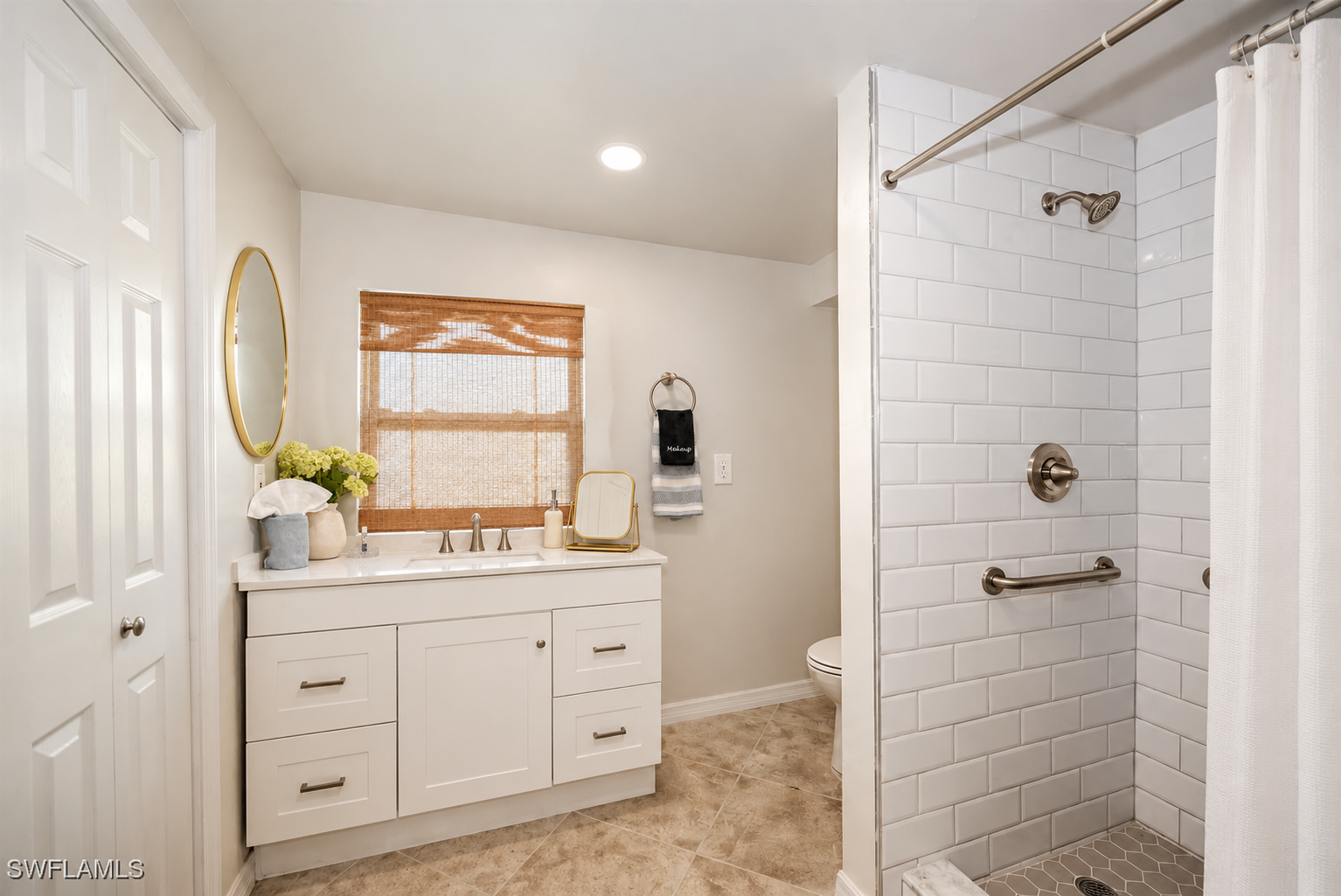 Bright modern bath with tiled walk-in shower and stylish vanity
