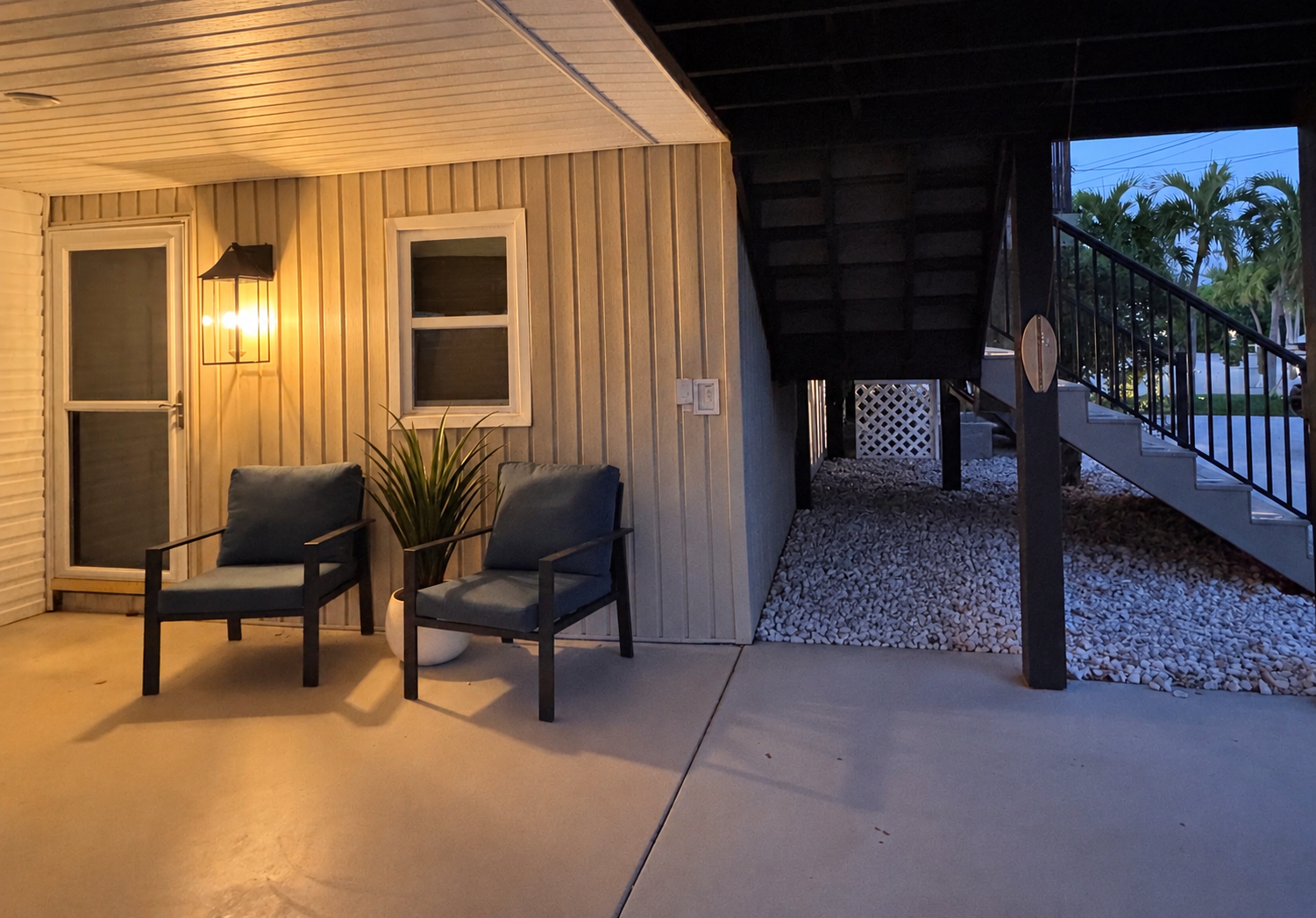 Cozy covered patio entry with lounge seating and warm evening ambiance