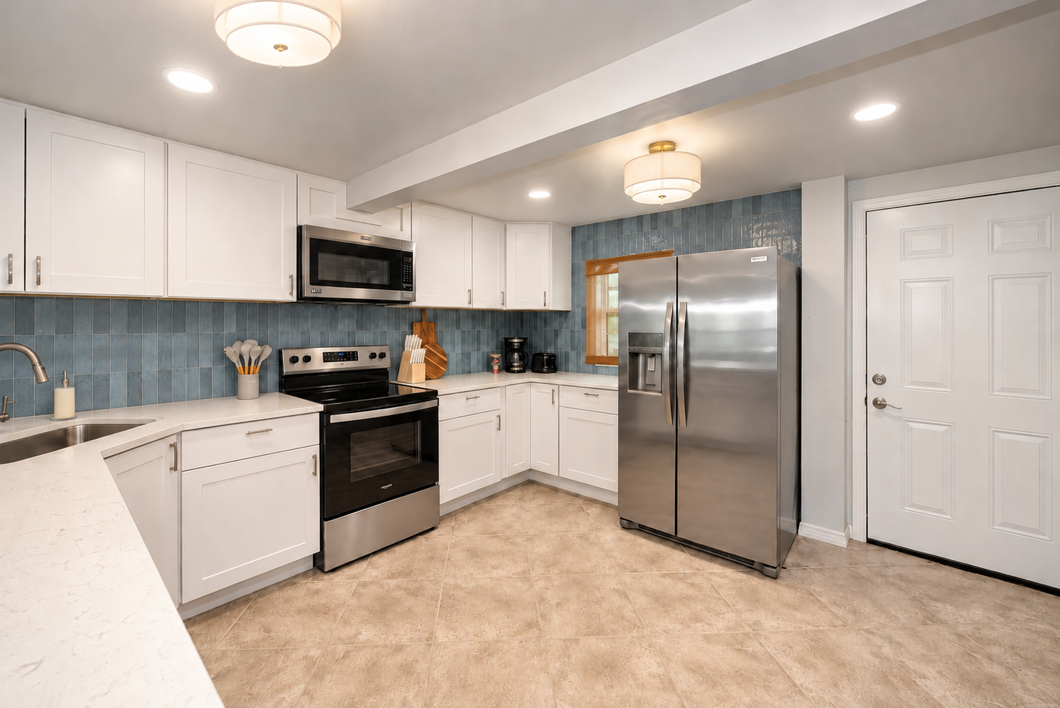 Bright modern kitchen with stainless appliances and stylish blue backsplash