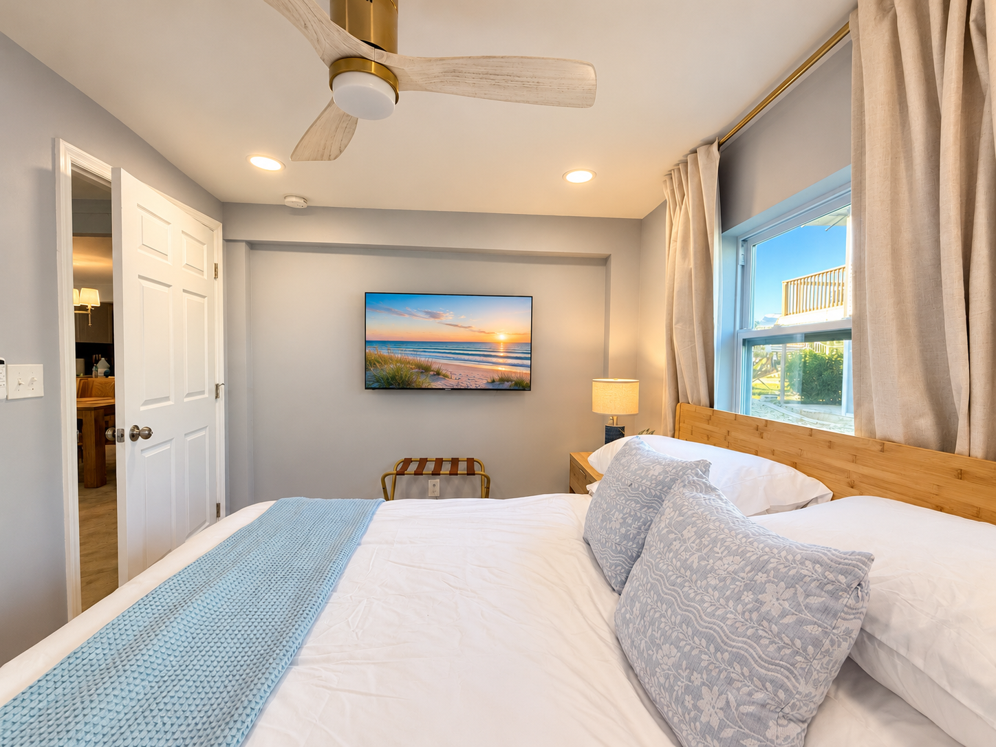 Coastal-inspired bedroom with king bed, natural light, and ensuite access