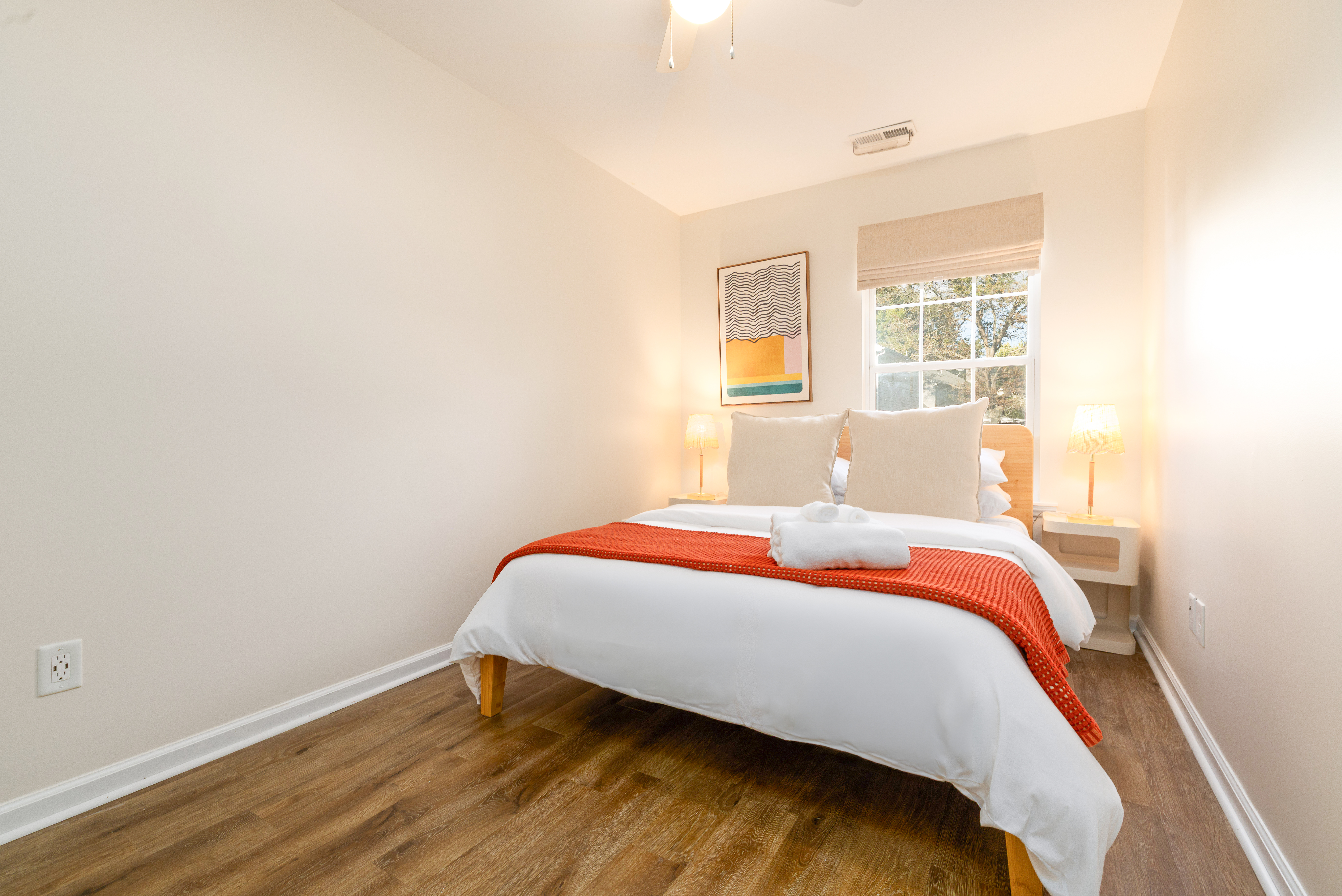 Bedroom 3: queen bed, blackout roman shade and wall sconce