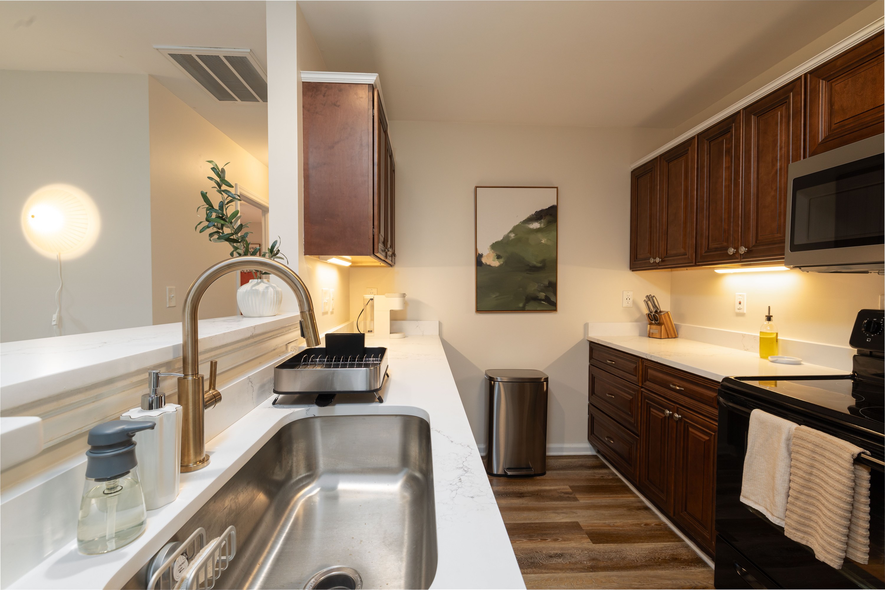 Galley kitchen with quartz counters and wood cabinets