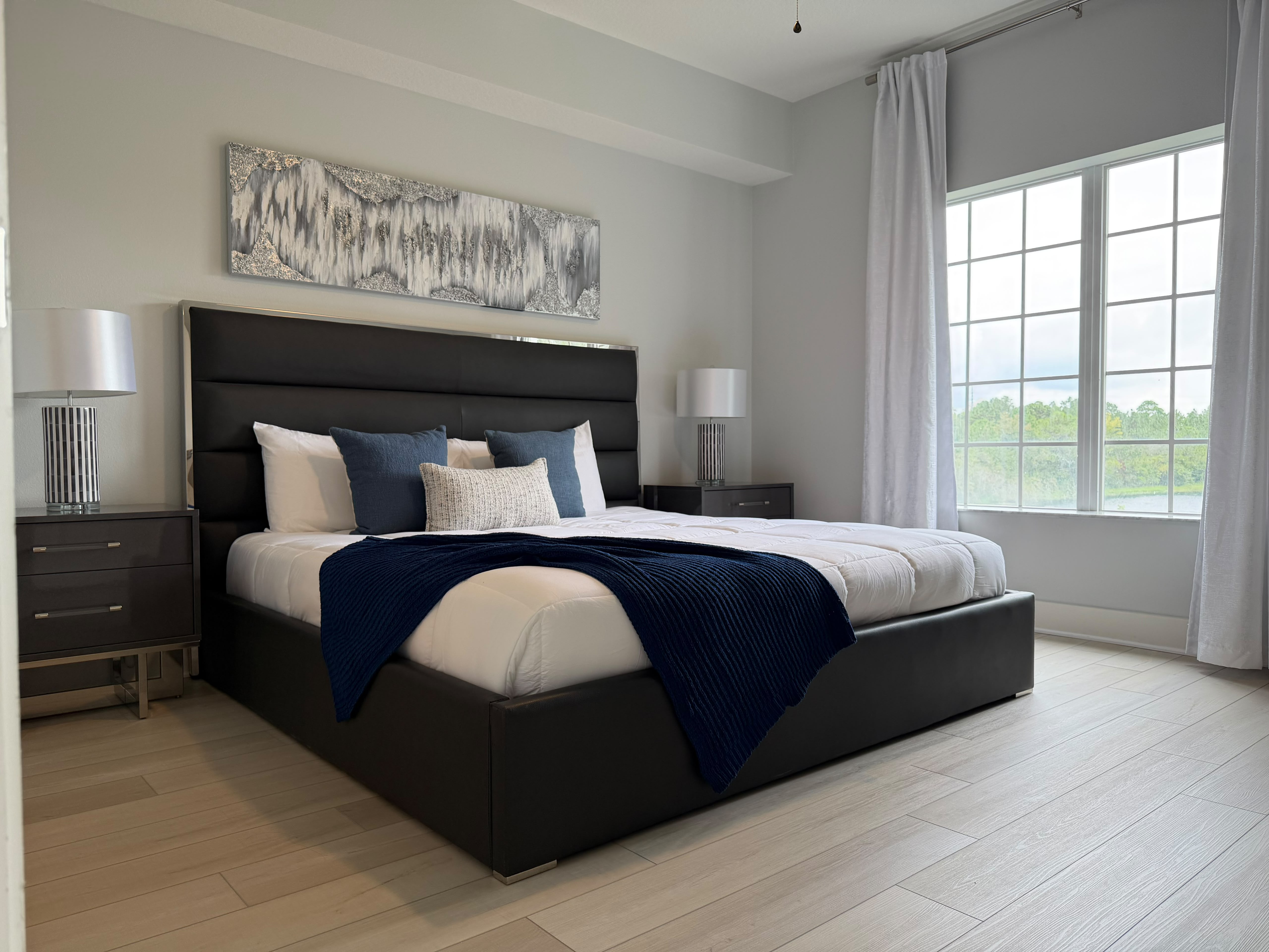 Bright, modern bedroom with a king bed and large sun-filled windows