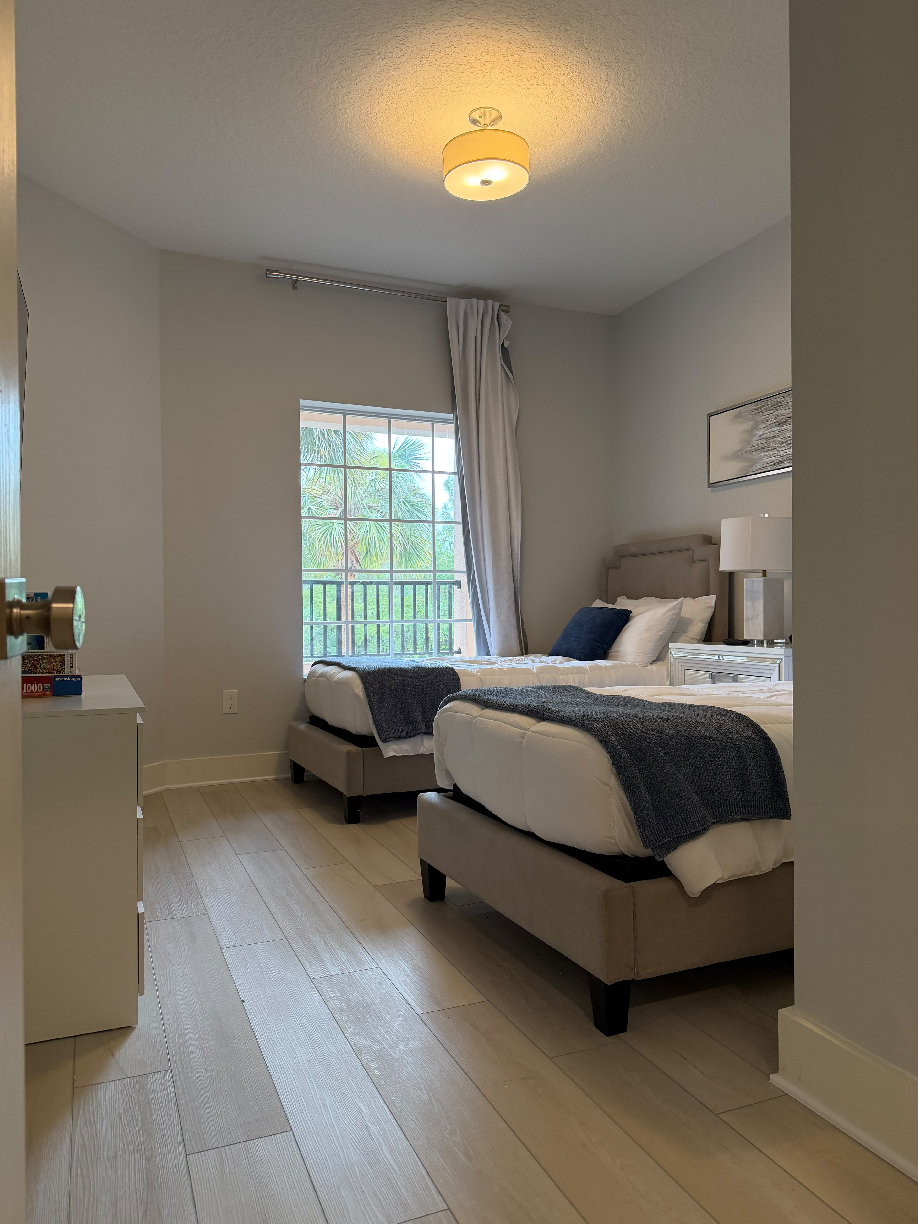 Bright twin bedroom with modern finishes and peaceful window views