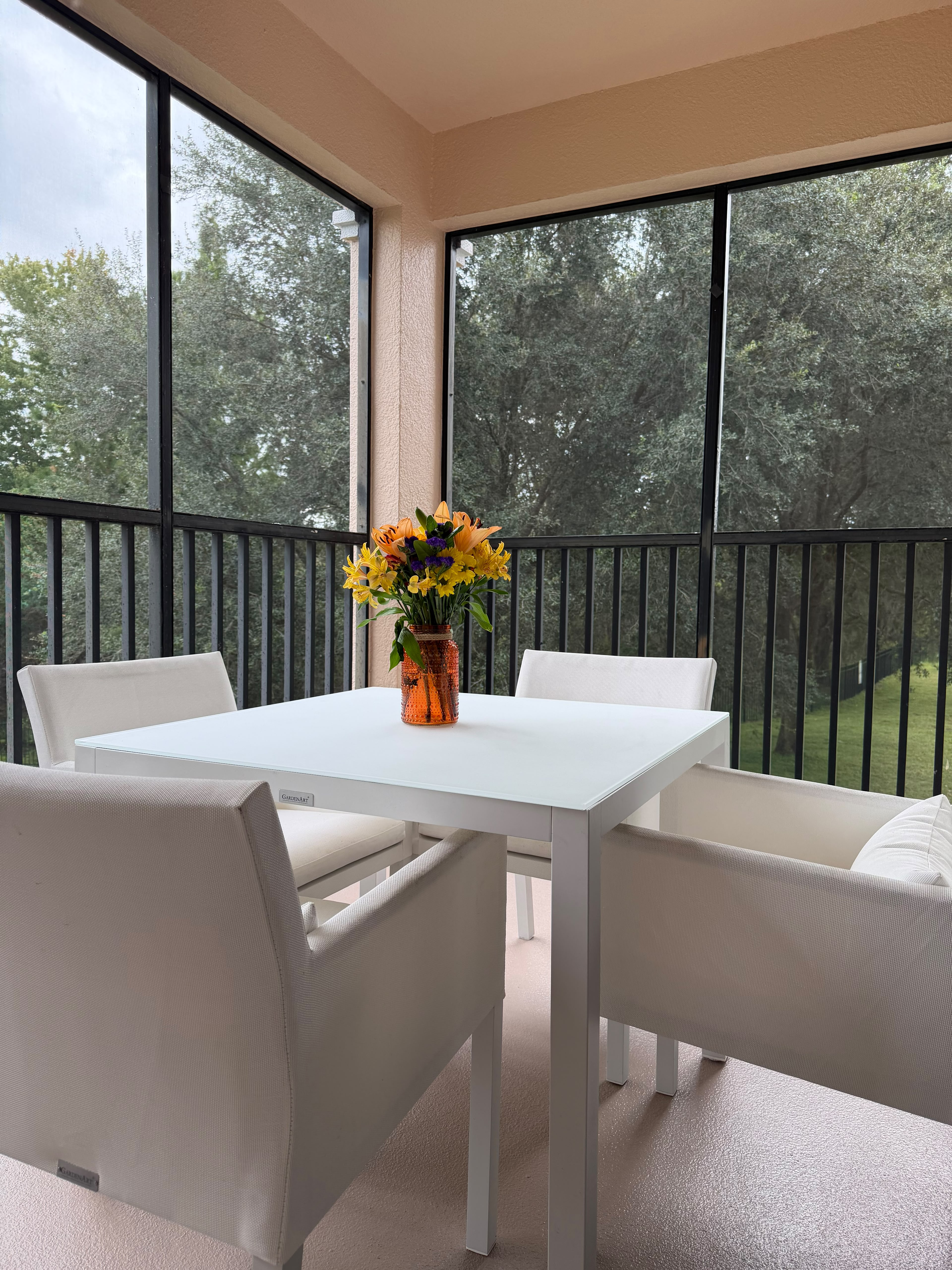 Screened patio dining with serene tree views and bright, modern seating