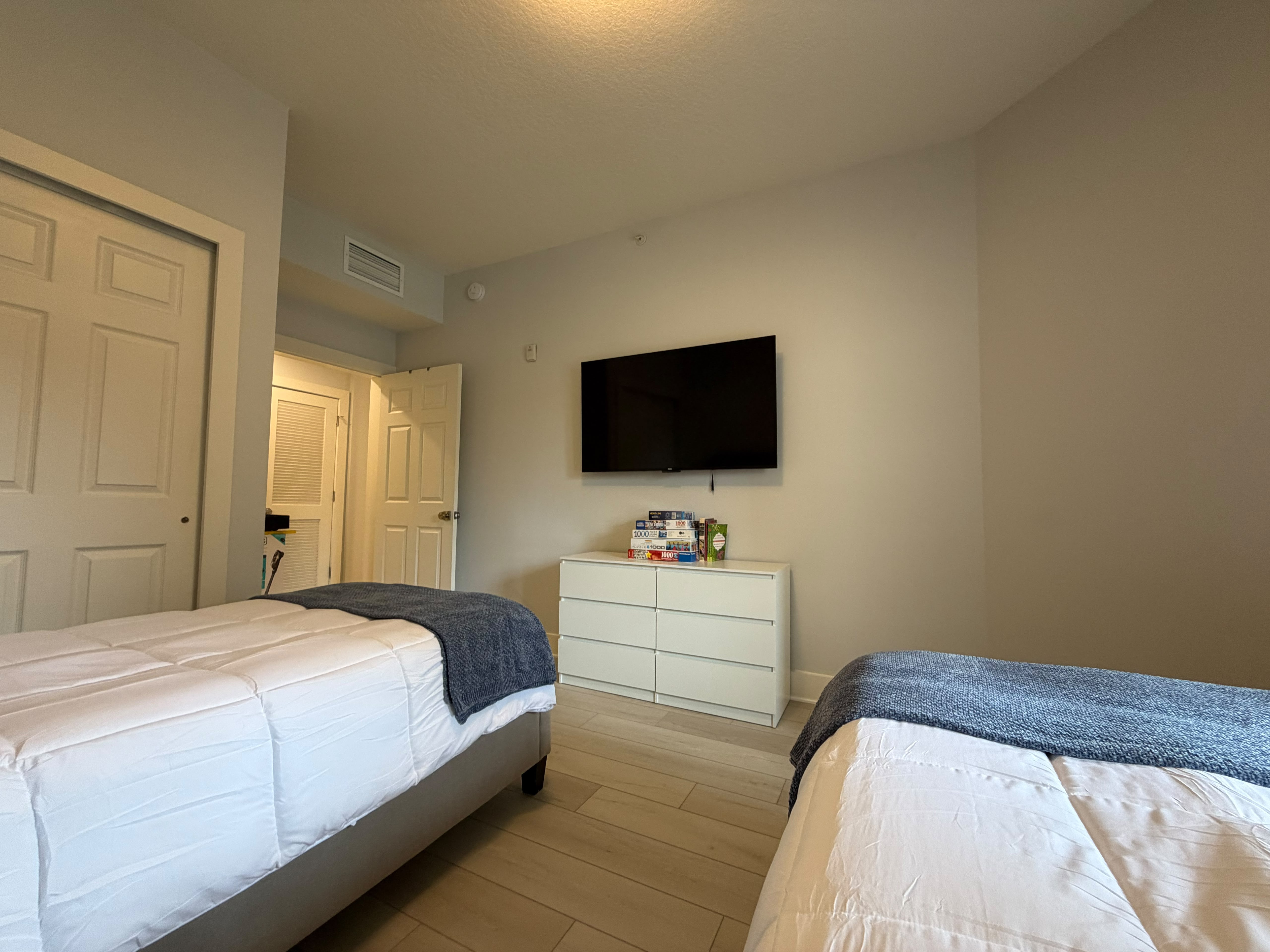 Bright twin bedroom with two beds, TV, and a clean modern design
