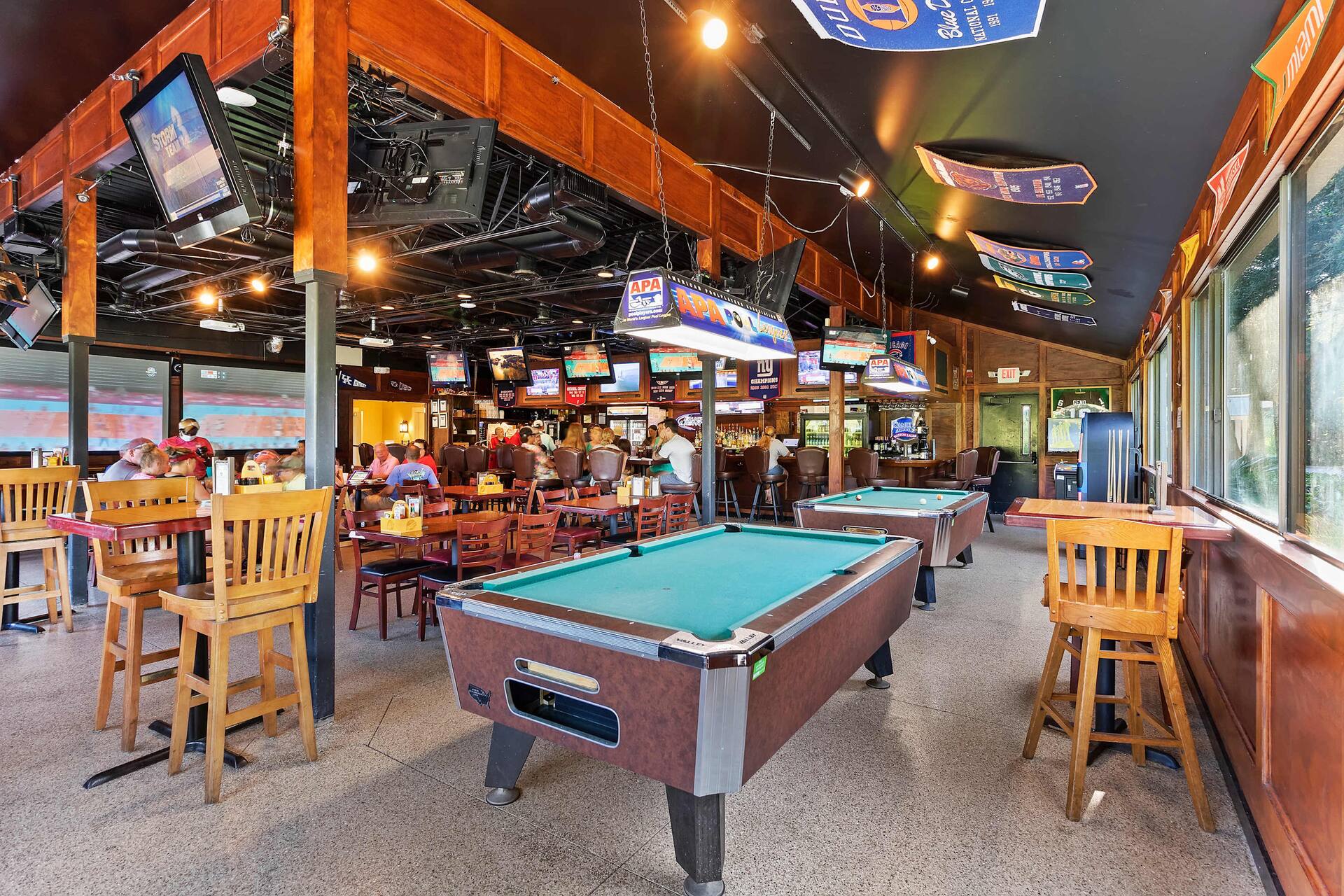 Spacious sports bar with pool tables, big-screen TVs, and lively seating