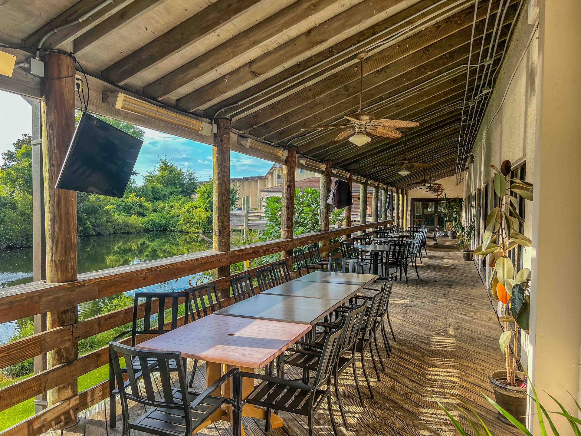 Spacious covered waterfront deck with dining seating and scenic views