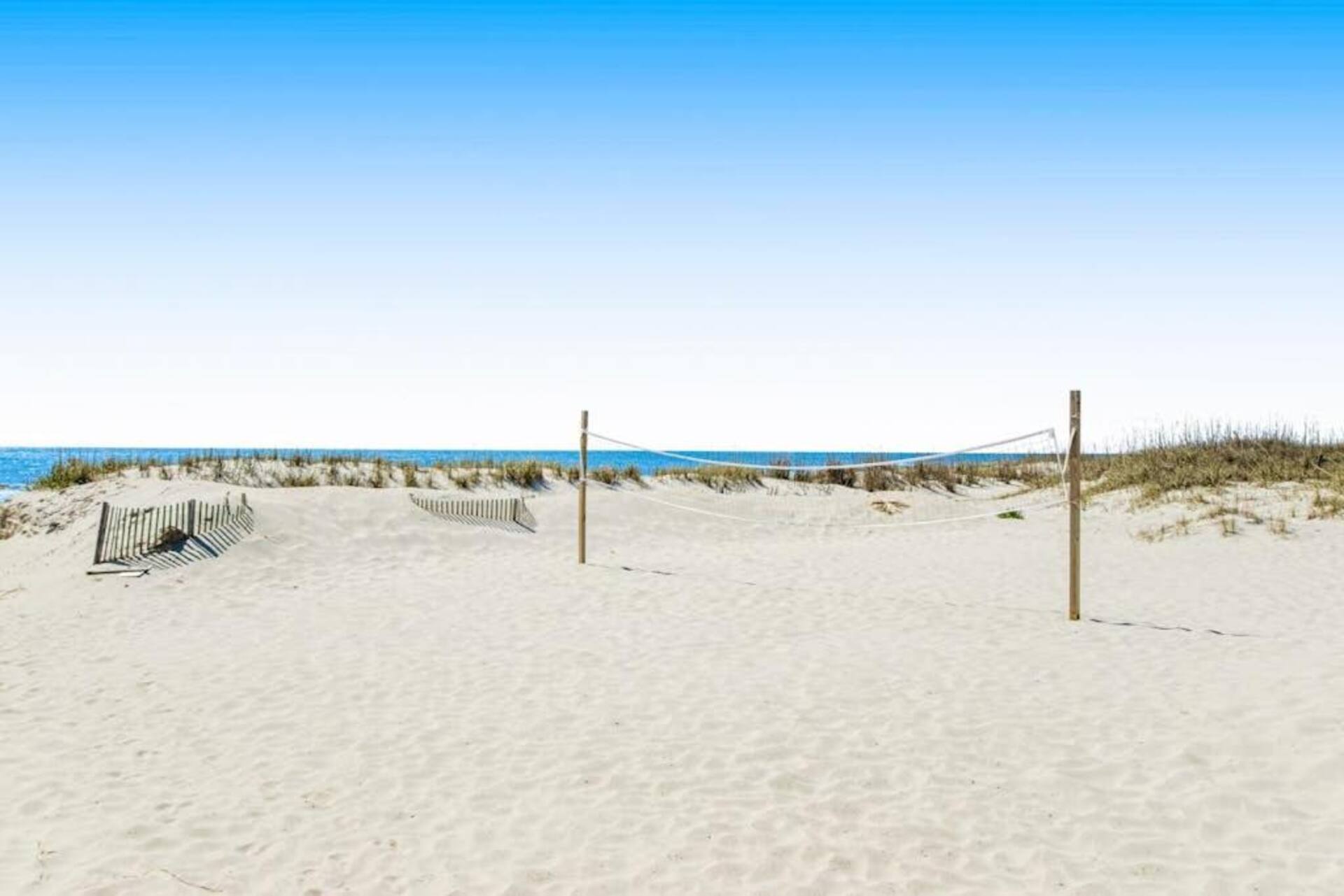 Sandy beach access with volleyball net and ocean views