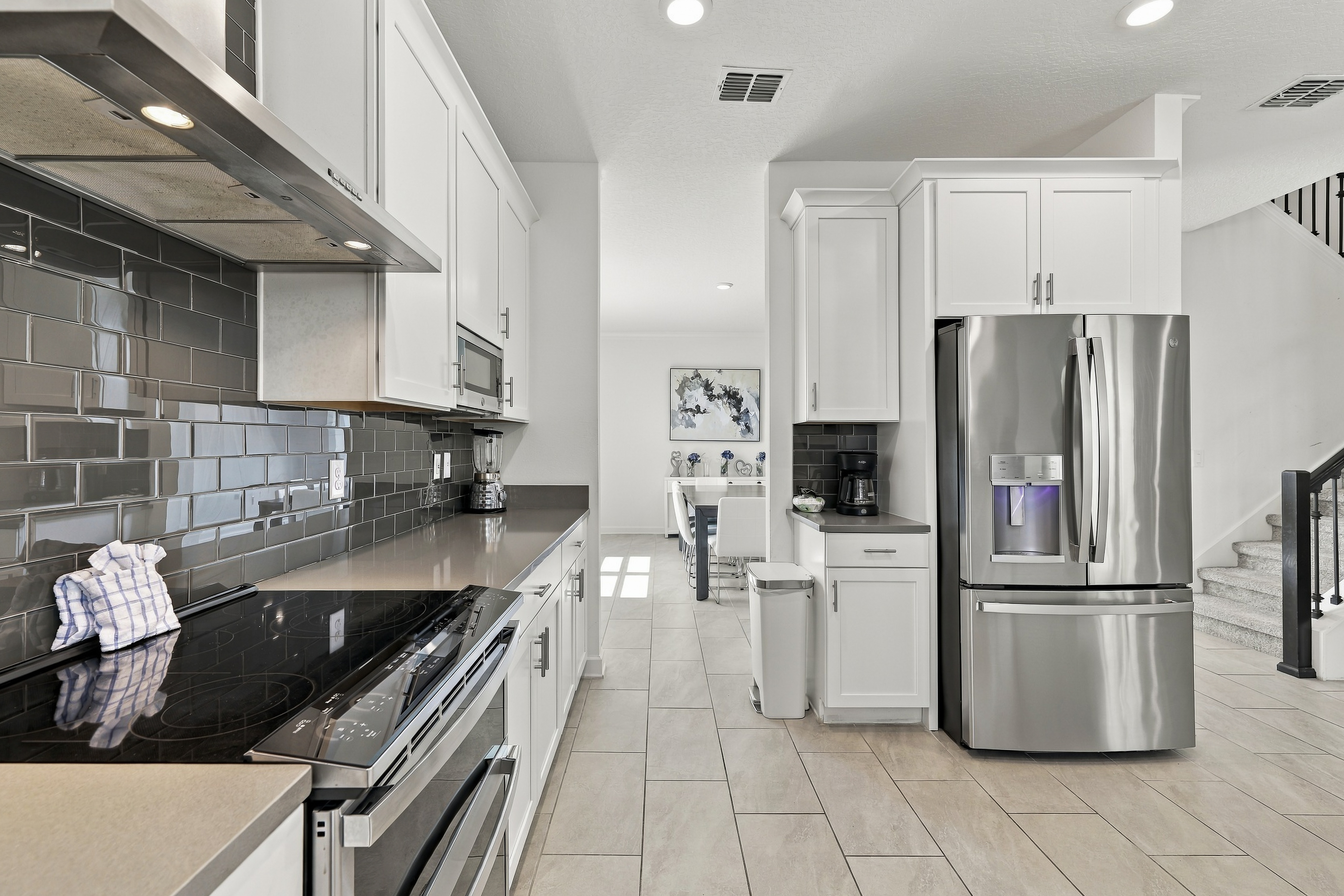 Bright modern kitchen with stainless steel appliances and open dining flow