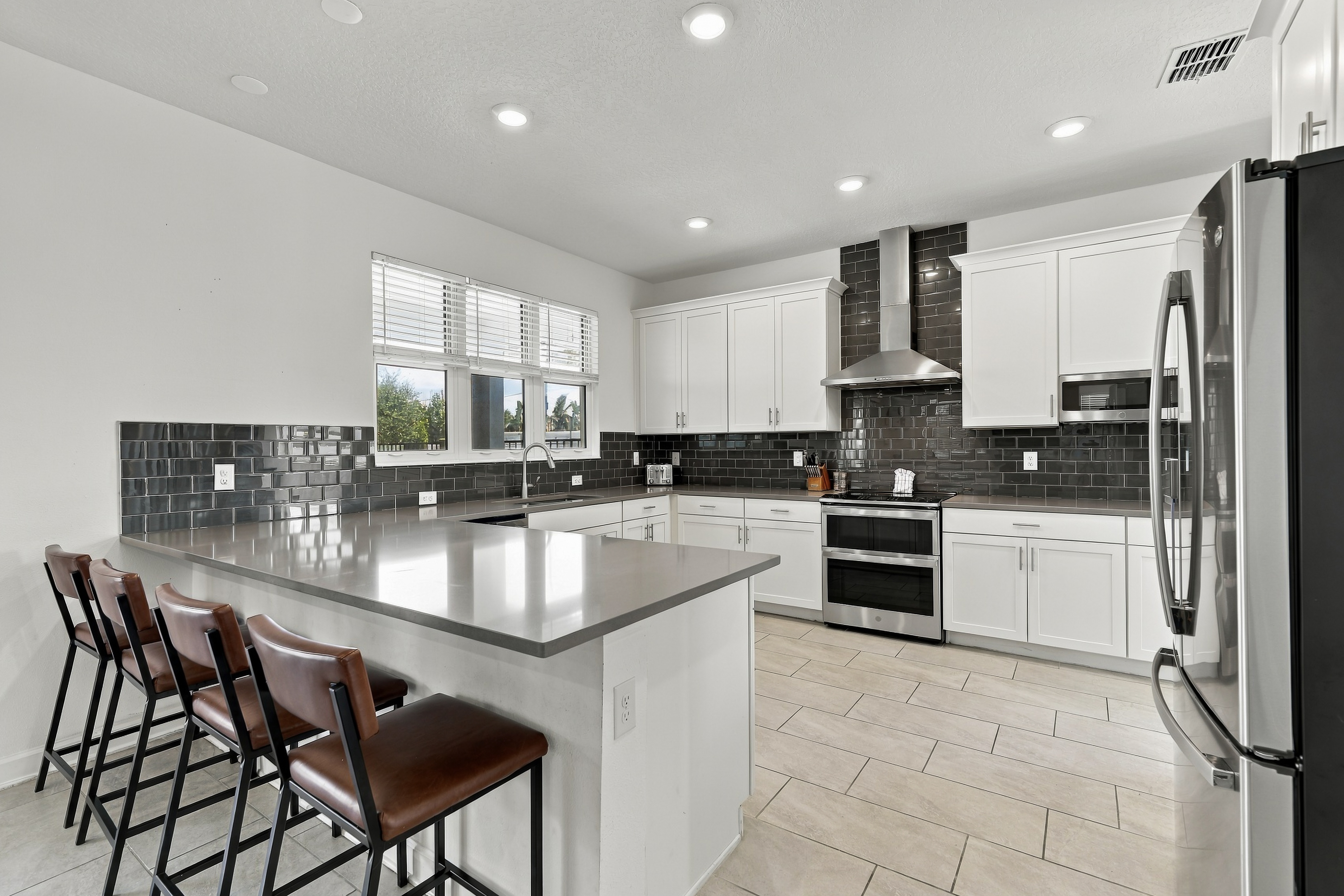 Modern chef’s kitchen with island seating for four and sleek finishes
