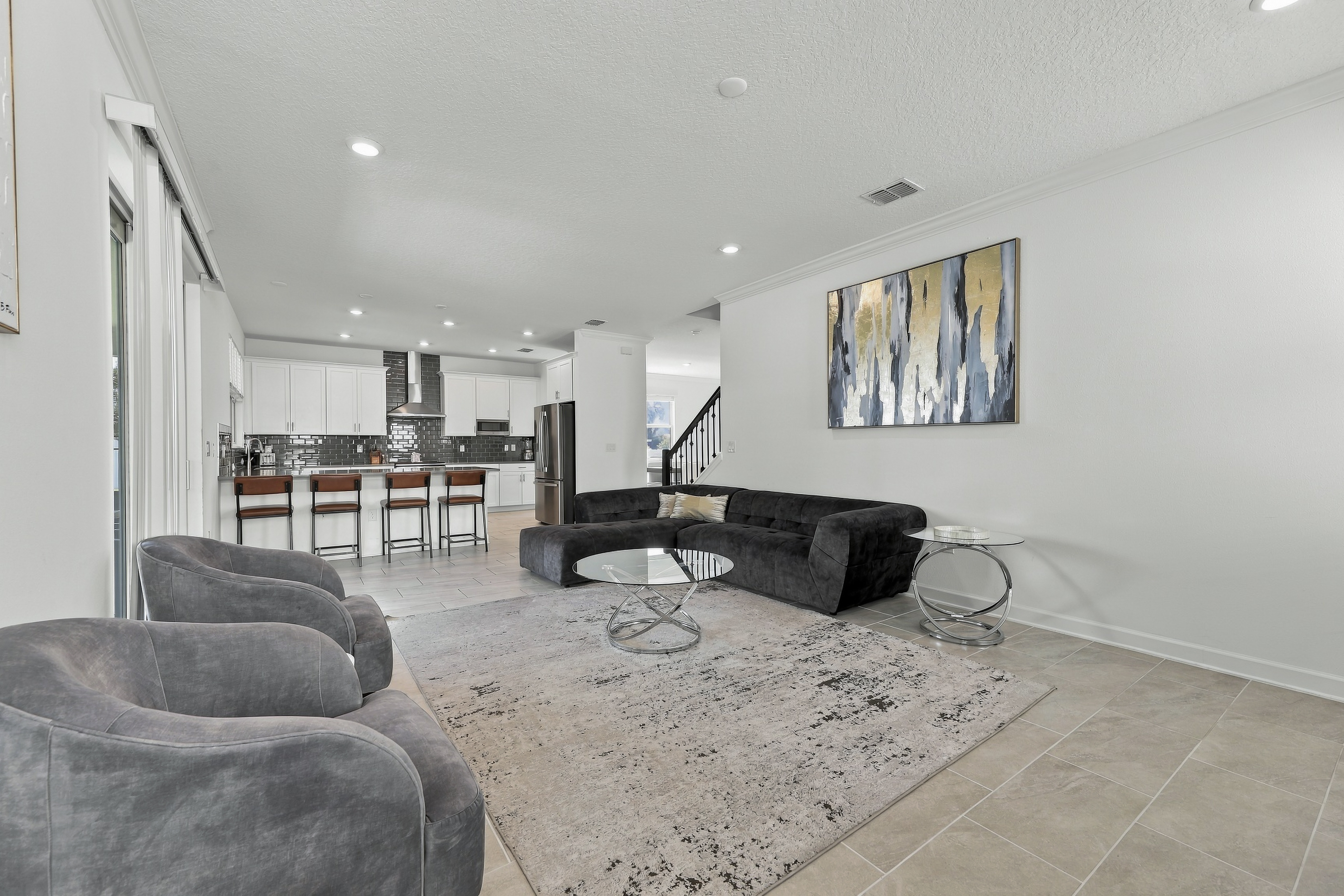 Bright open living room with stylish kitchen and bar seating