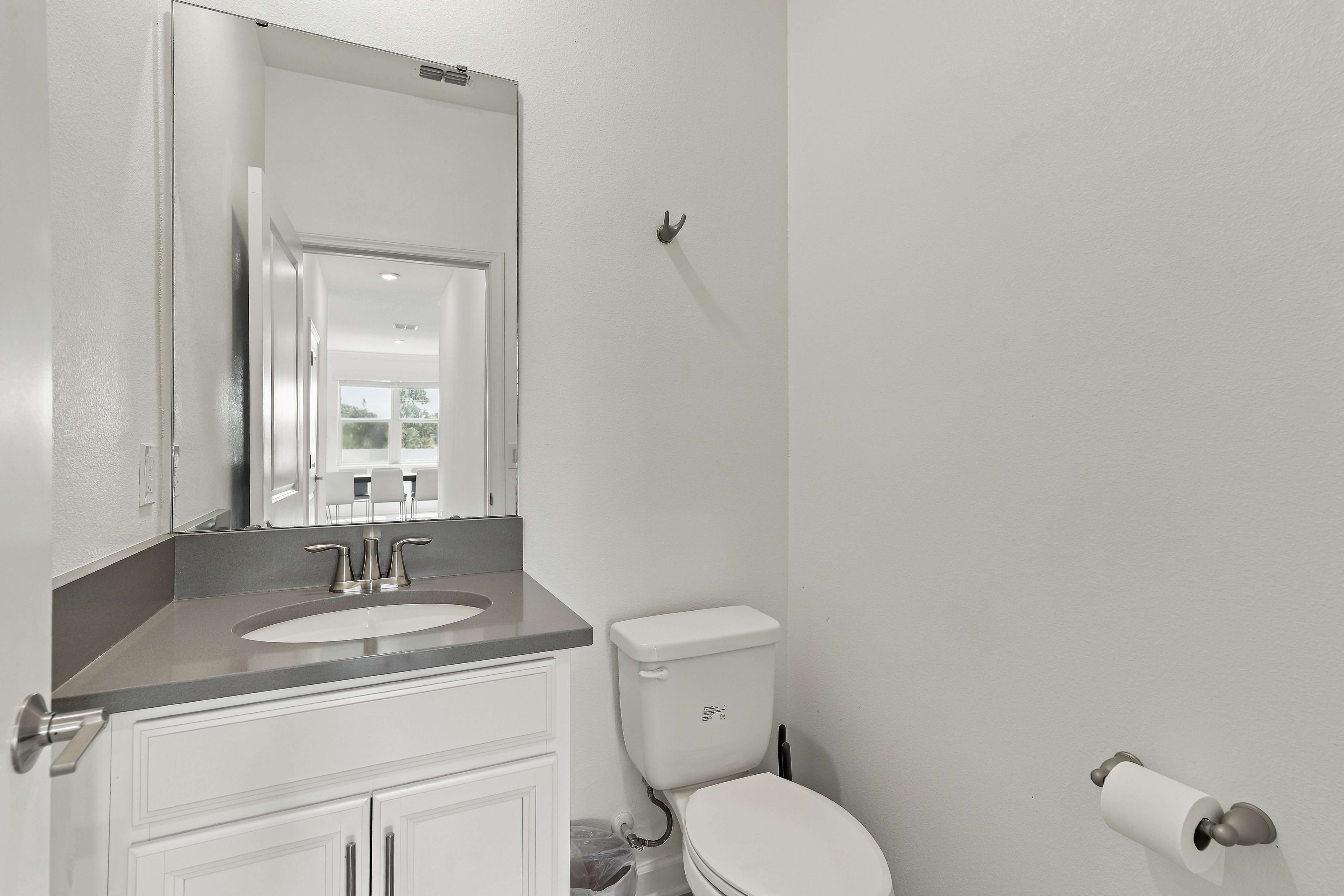 Bright modern half bath with sleek vanity and fresh neutral finishes