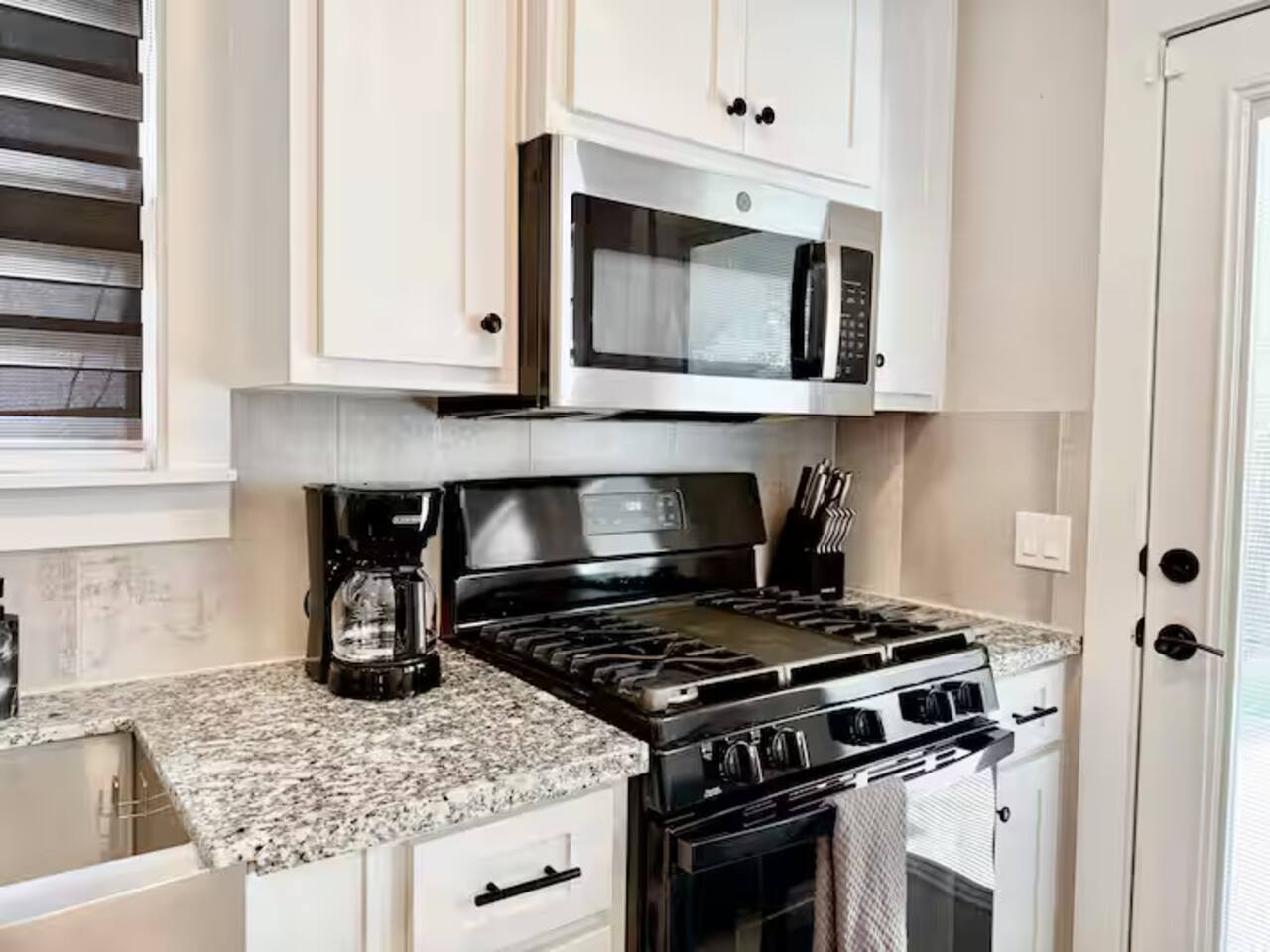 Cook in style! This modern  kitchen features sleek stainless steel appliances, a spacious island with seating for three, and plenty of counter space. Ideal for morning coffee or gourmet dinners.