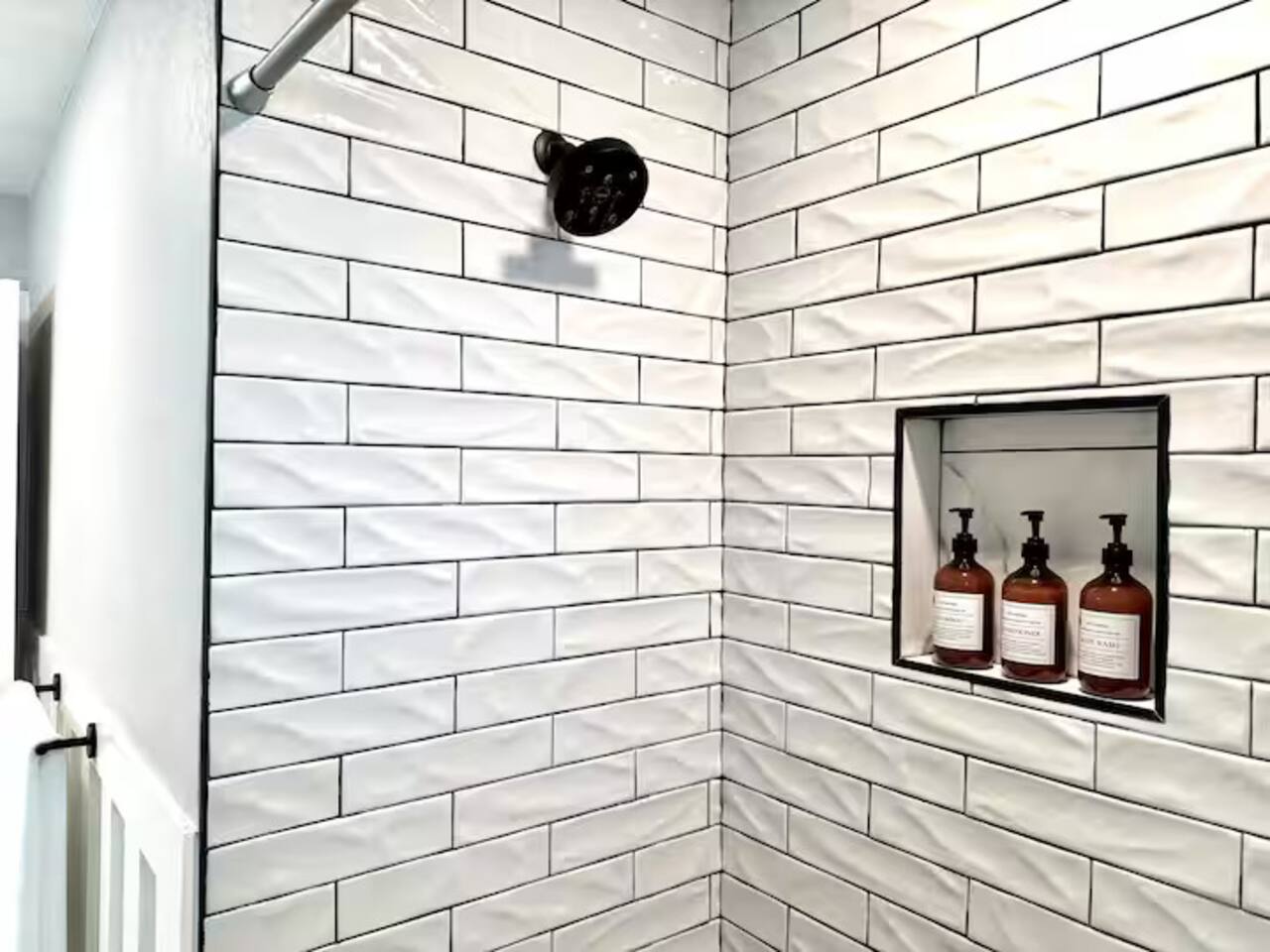 Refresh in this spa-like sanctuary featuring elegant marble-style flooring, chic wainscoting, and premium matte black fixtures. Enjoy a bright, clean space complete with complimentary toiletries for a high-end stay.