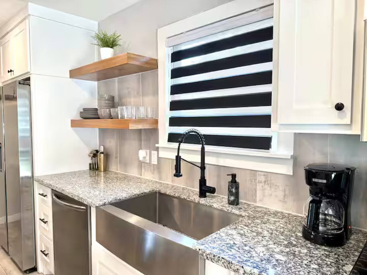 Cook in style! This modern  kitchen features sleek stainless steel appliances, a spacious island with seating for three, and plenty of counter space. Ideal for morning coffee or gourmet dinners.