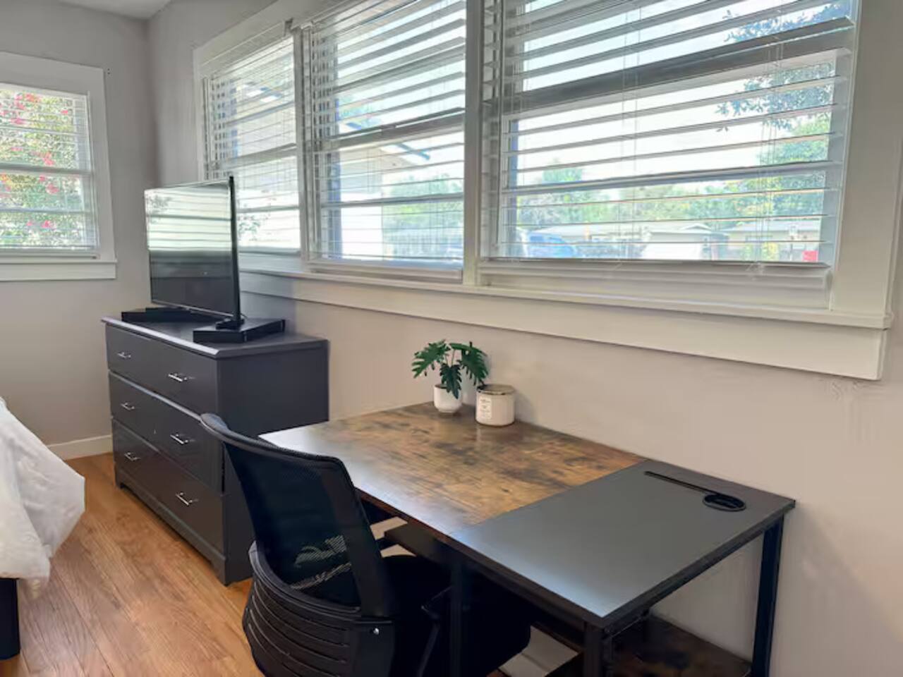 Relax in this peaceful, sun-drenched bedroom. Features include a plush queen bed with crisp white linens, a dedicated work-from-home desk, and a smart TV for late-night movie marathons.