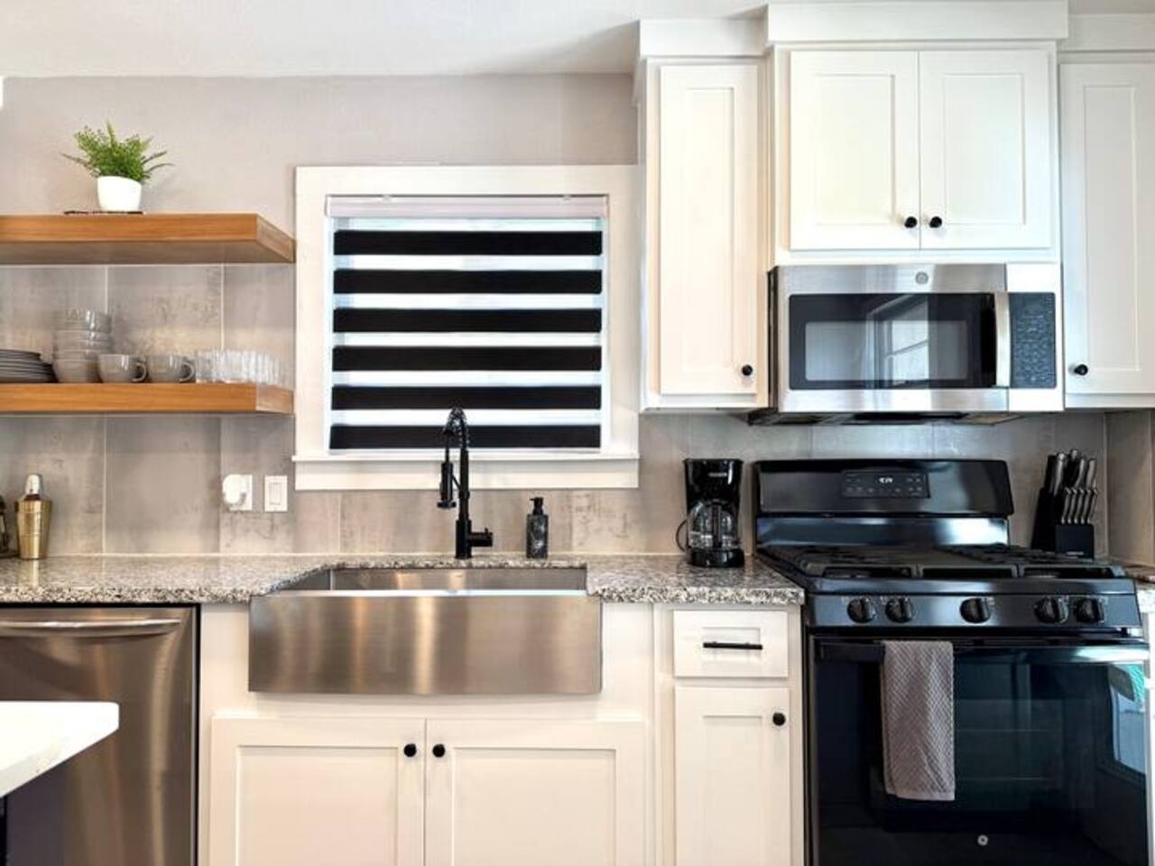 Cook in style! This modern  kitchen features sleek stainless steel appliances, a spacious island with seating for three, and plenty of counter space. Ideal for morning coffee or gourmet dinners.