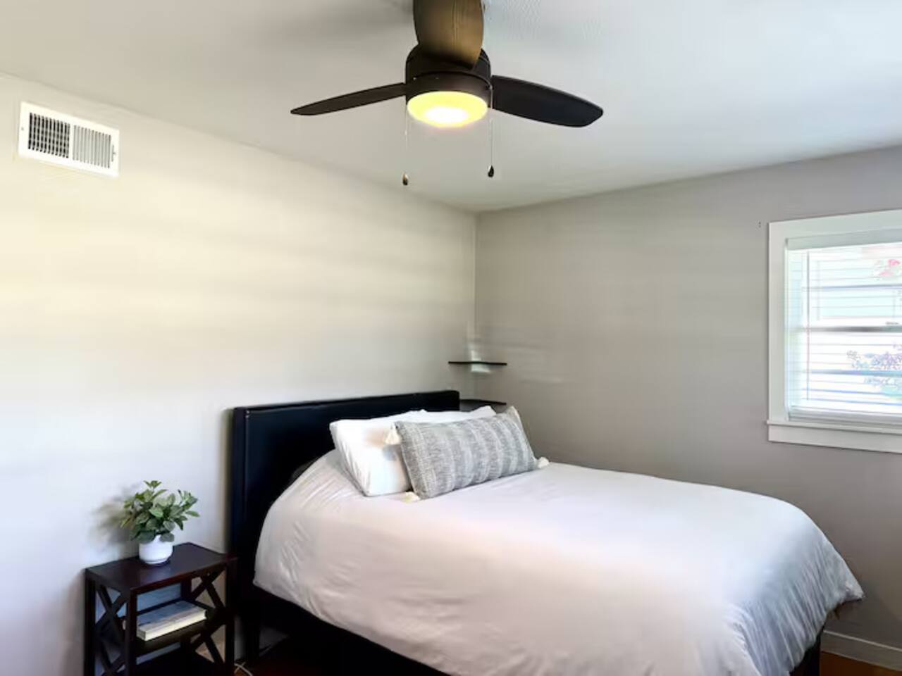 Relax in this peaceful, sun-drenched bedroom designed for comfort. It features a plush queen bed, a dedicated workspace with a desk, and a large smart TV for all your entertainment needs.