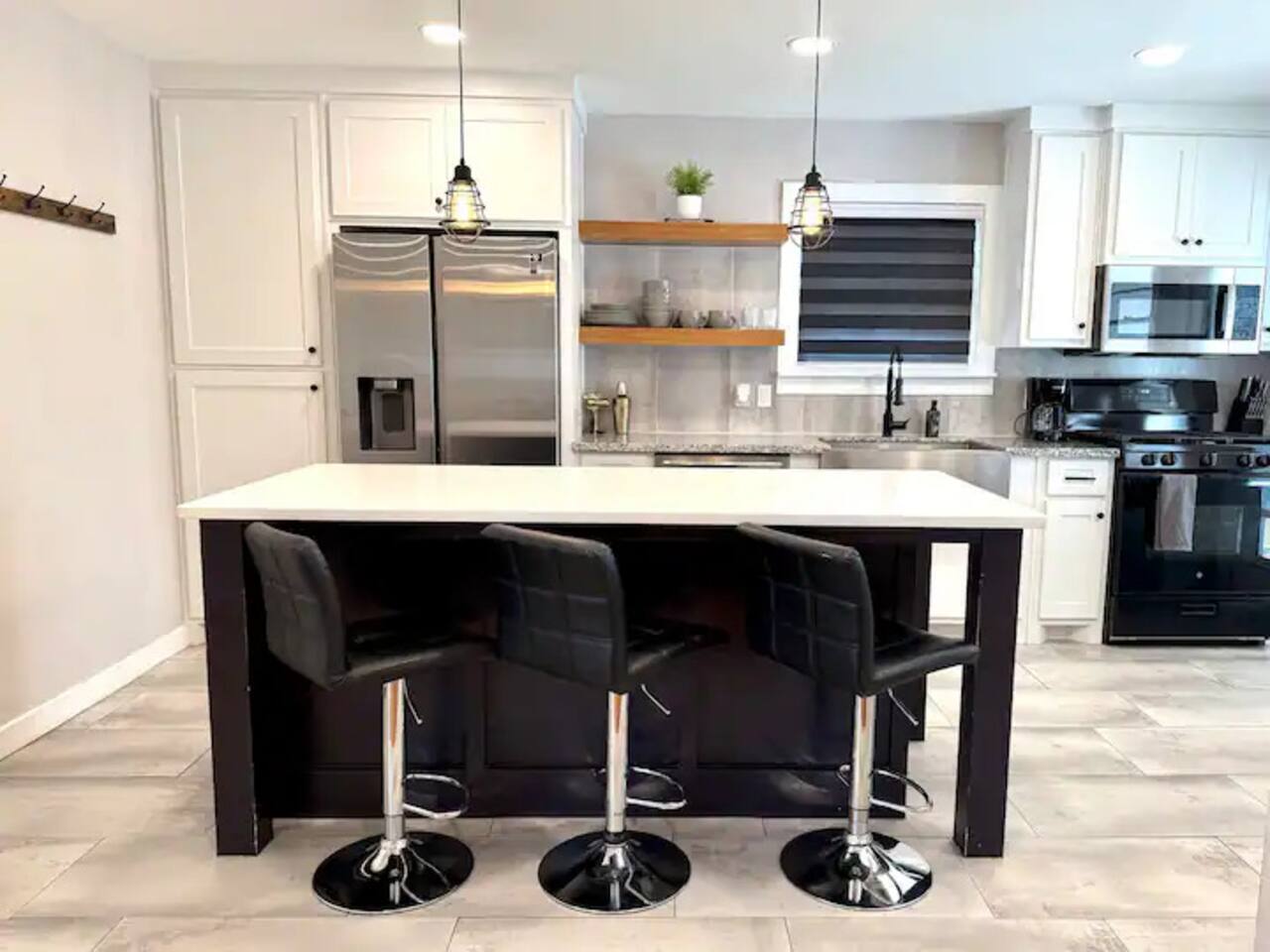 Cook in style! This modern  kitchen features sleek stainless steel appliances, a spacious island with seating for three, and plenty of counter space. Ideal for morning coffee or gourmet dinners.