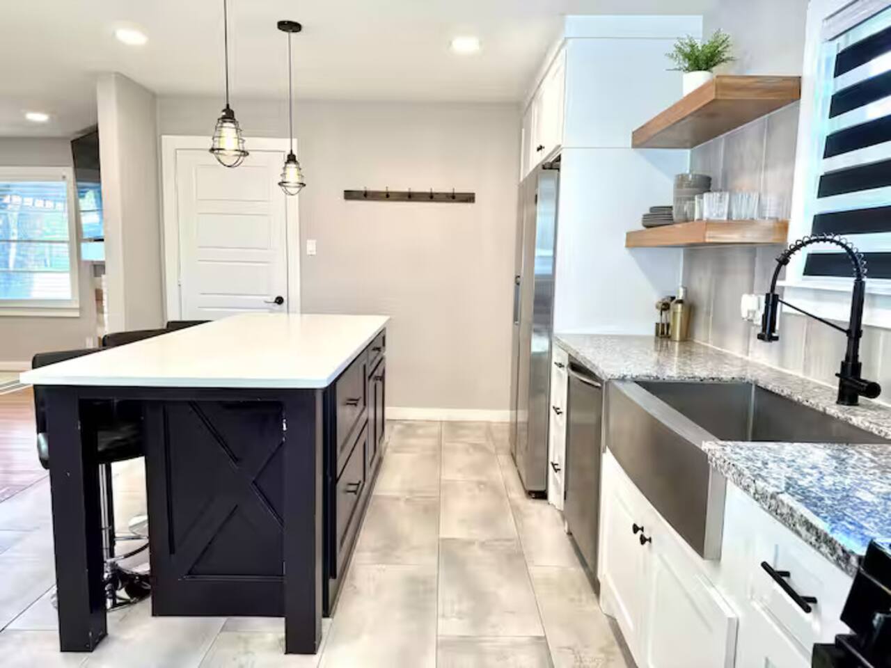 Cook in style! This modern  kitchen features sleek stainless steel appliances, a spacious island with seating for three, and plenty of counter space. Ideal for morning coffee or gourmet dinners.