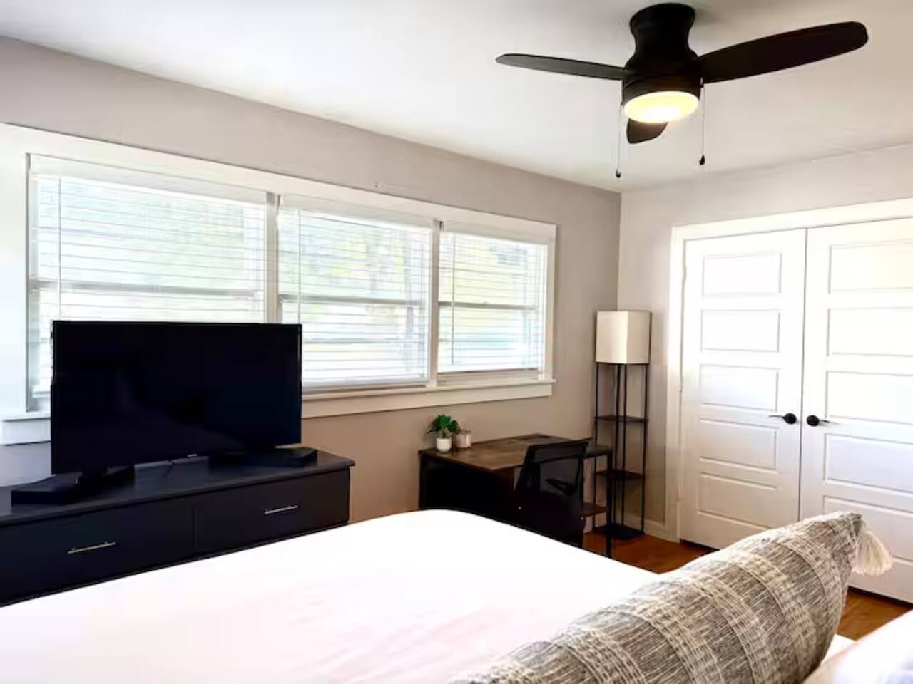 Relax in this peaceful, sun-drenched bedroom. Features include a plush bed with crisp linens, a dedicated work-from-home desk, and a smart TV for late-night movie marathons.