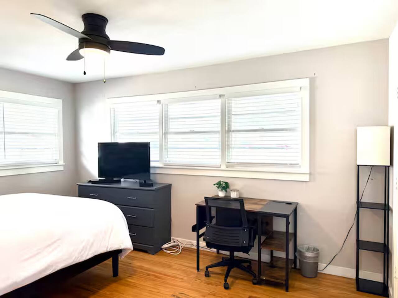 Relax in this peaceful, sun-drenched bedroom. Features include a plush queen bed with crisp white linens, a dedicated work-from-home desk, and a smart TV for late-night movie marathons.