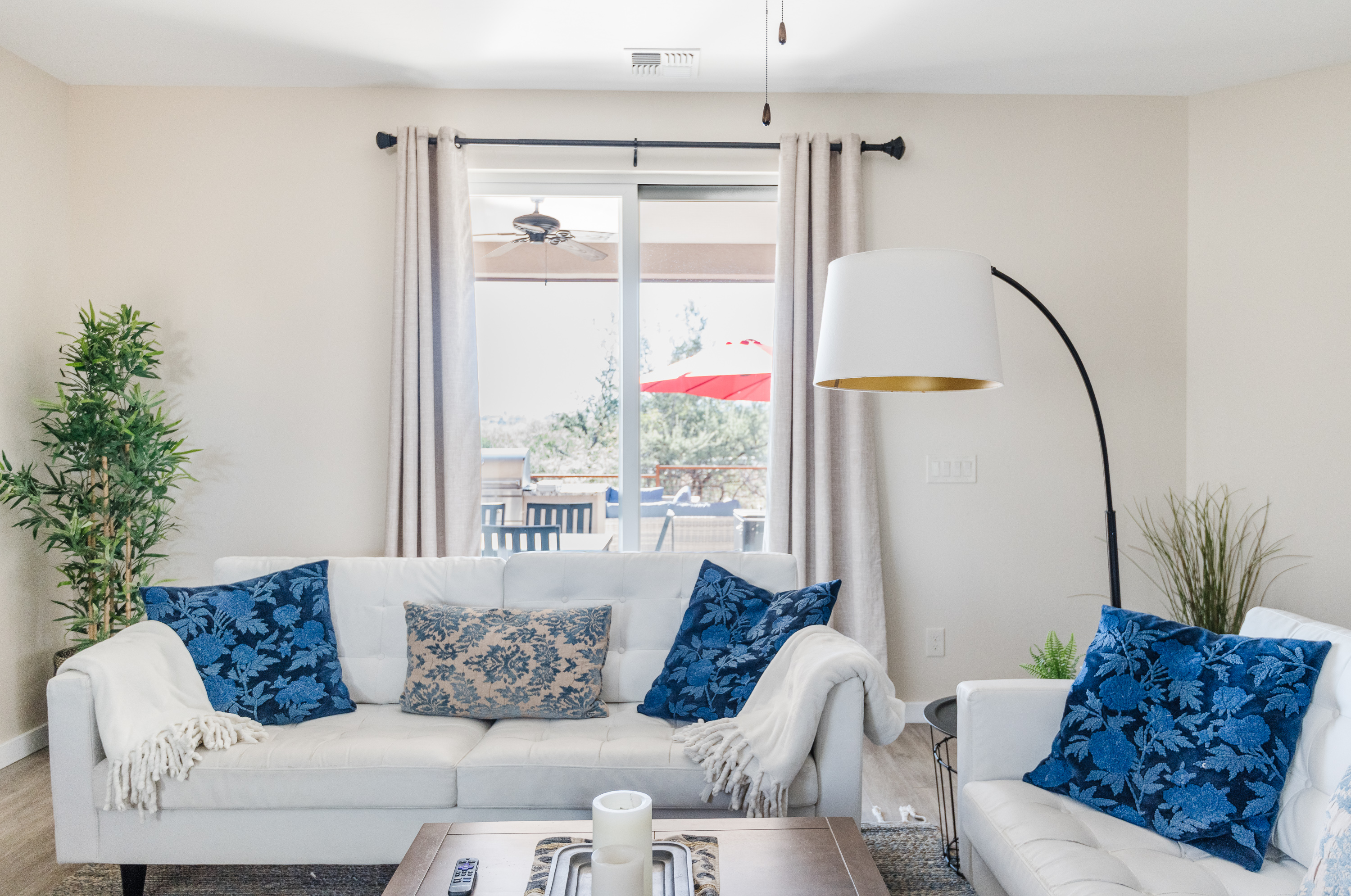 Bright living room with patio access, stylish blue accents, and cozy seating