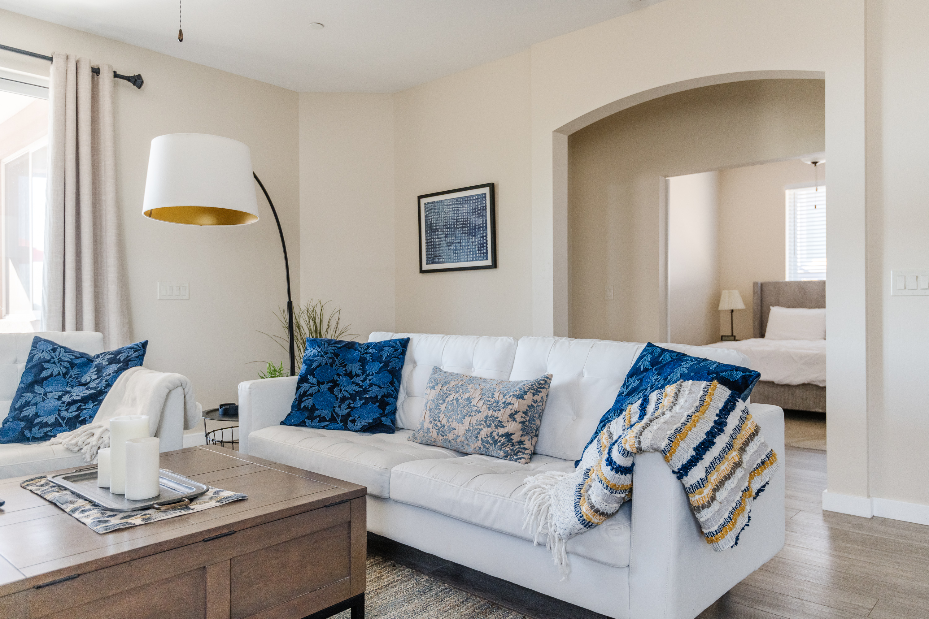 Bright, stylish living room with cozy seating and open bedroom access