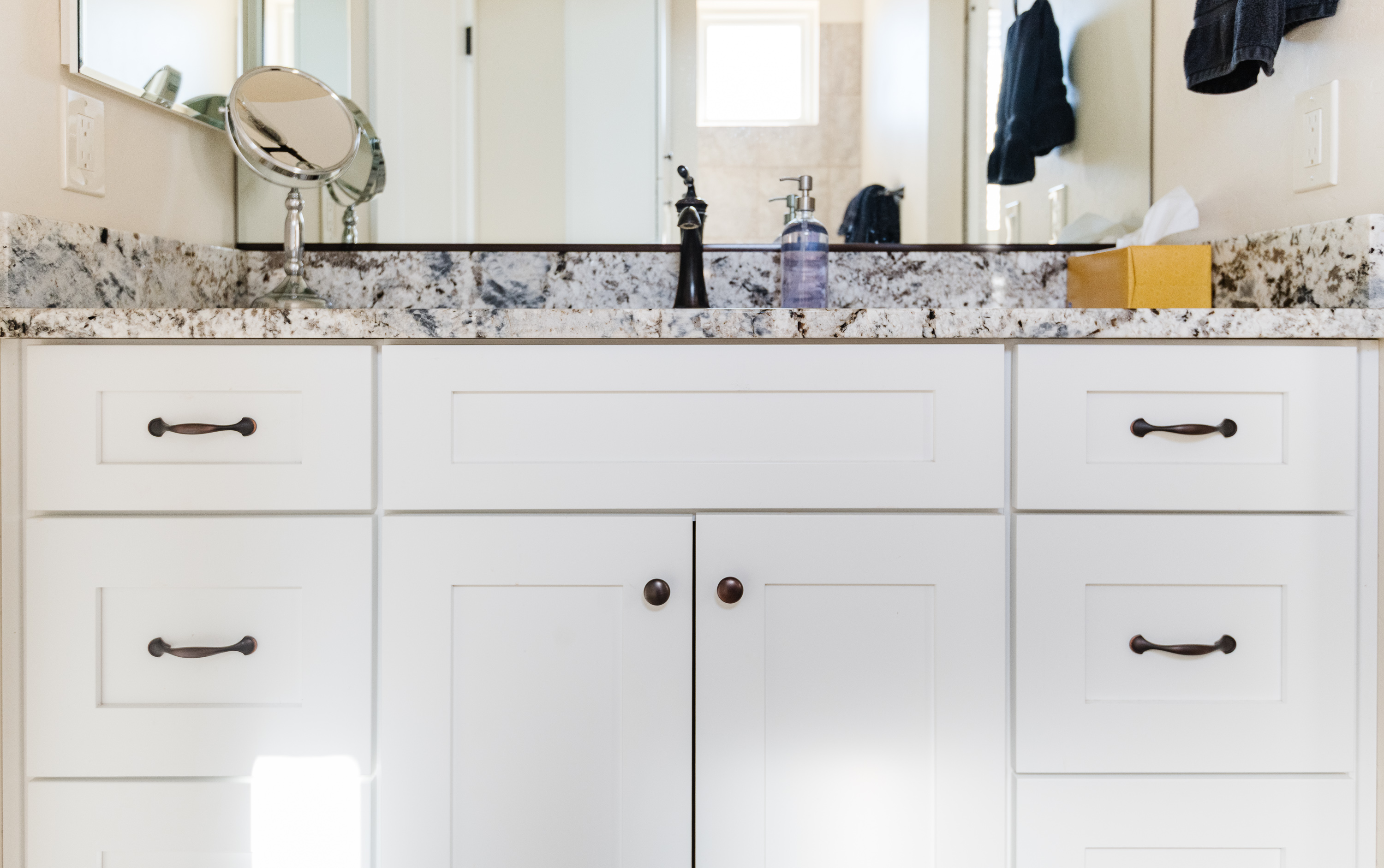 Bright modern bathroom vanity with granite counters and ample storage