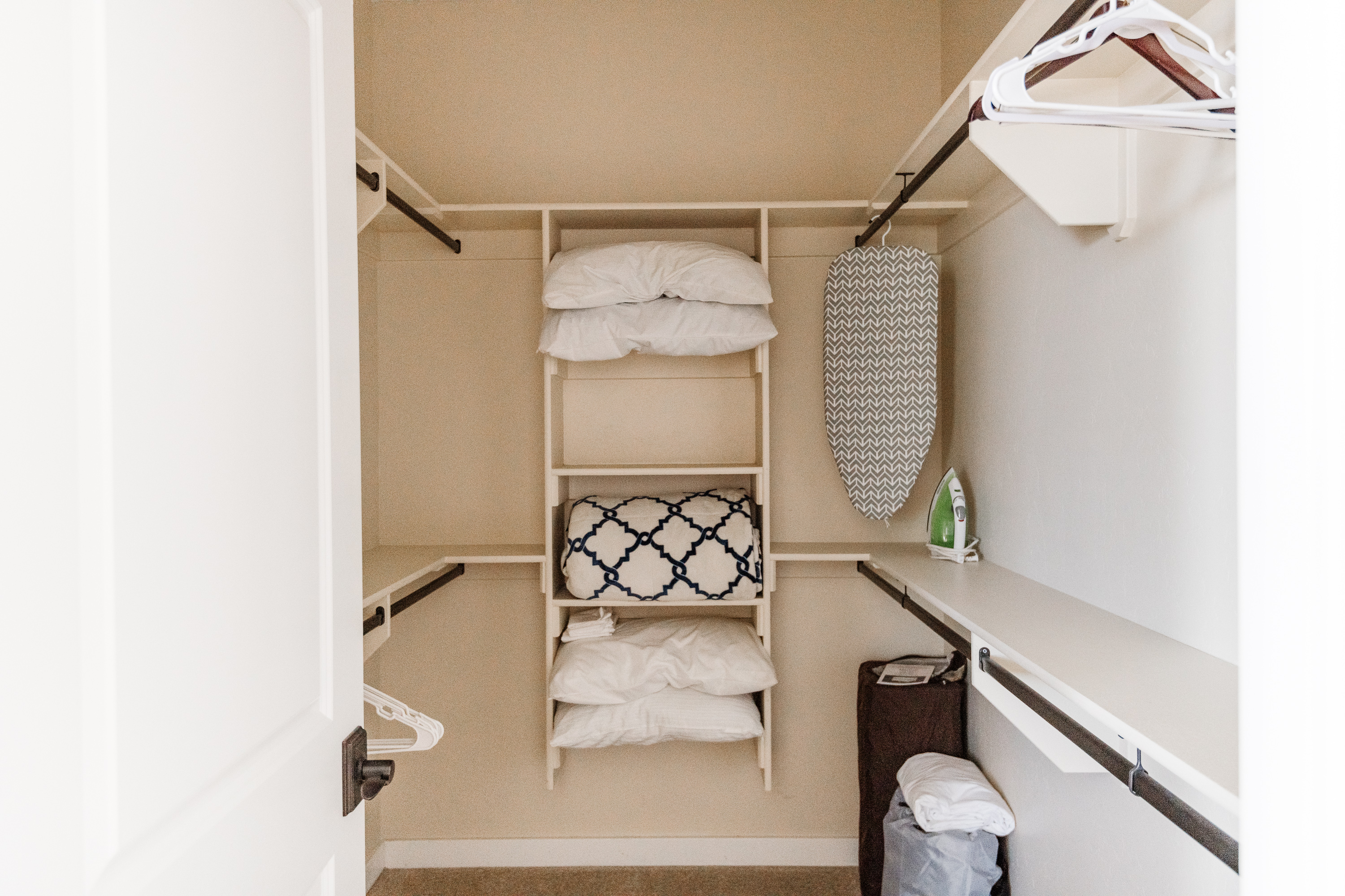 Spacious walk-in closet with extra linens, hangers, and ironing essentials