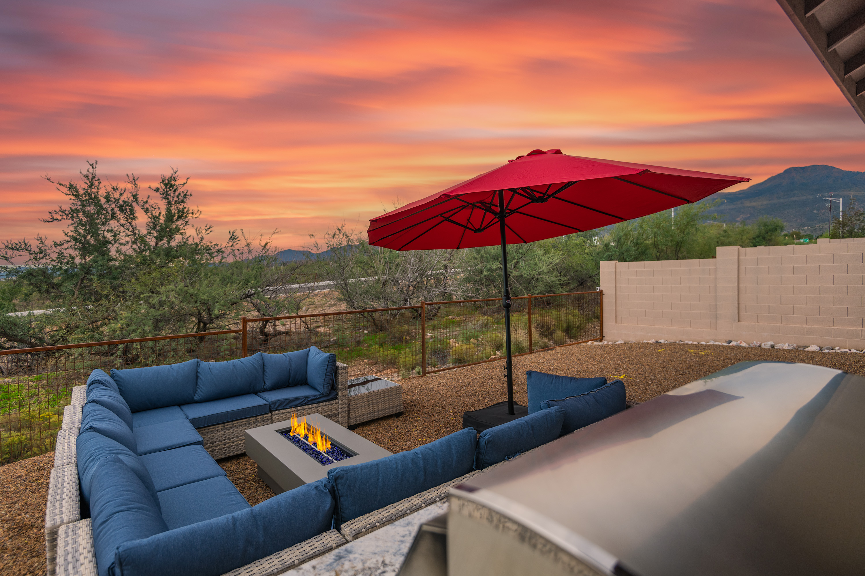Sunset patio with fire pit, grill, and mountain-view lounge seating