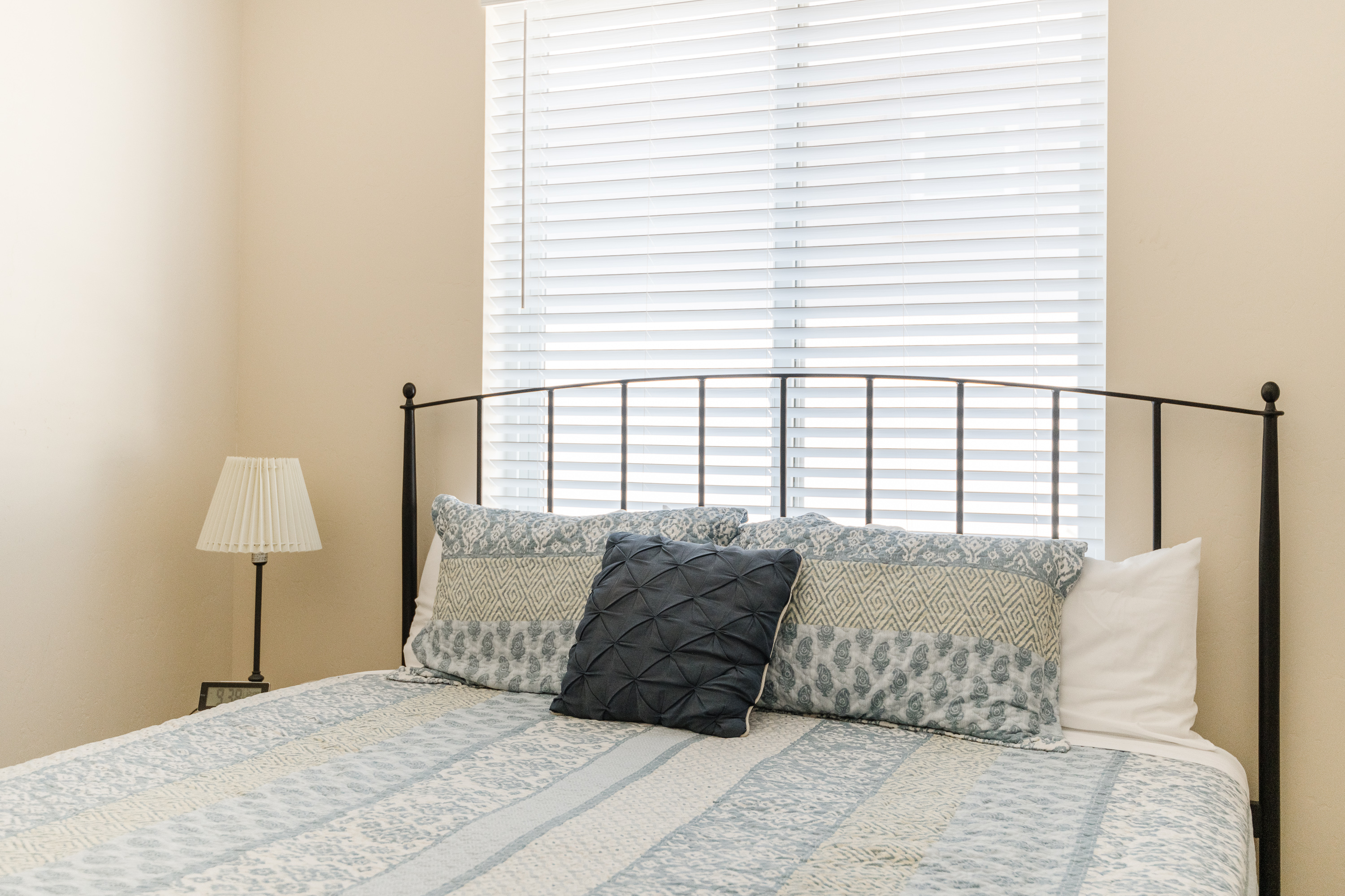 Bright, cozy bedroom with soft blue linens and plenty of natural light