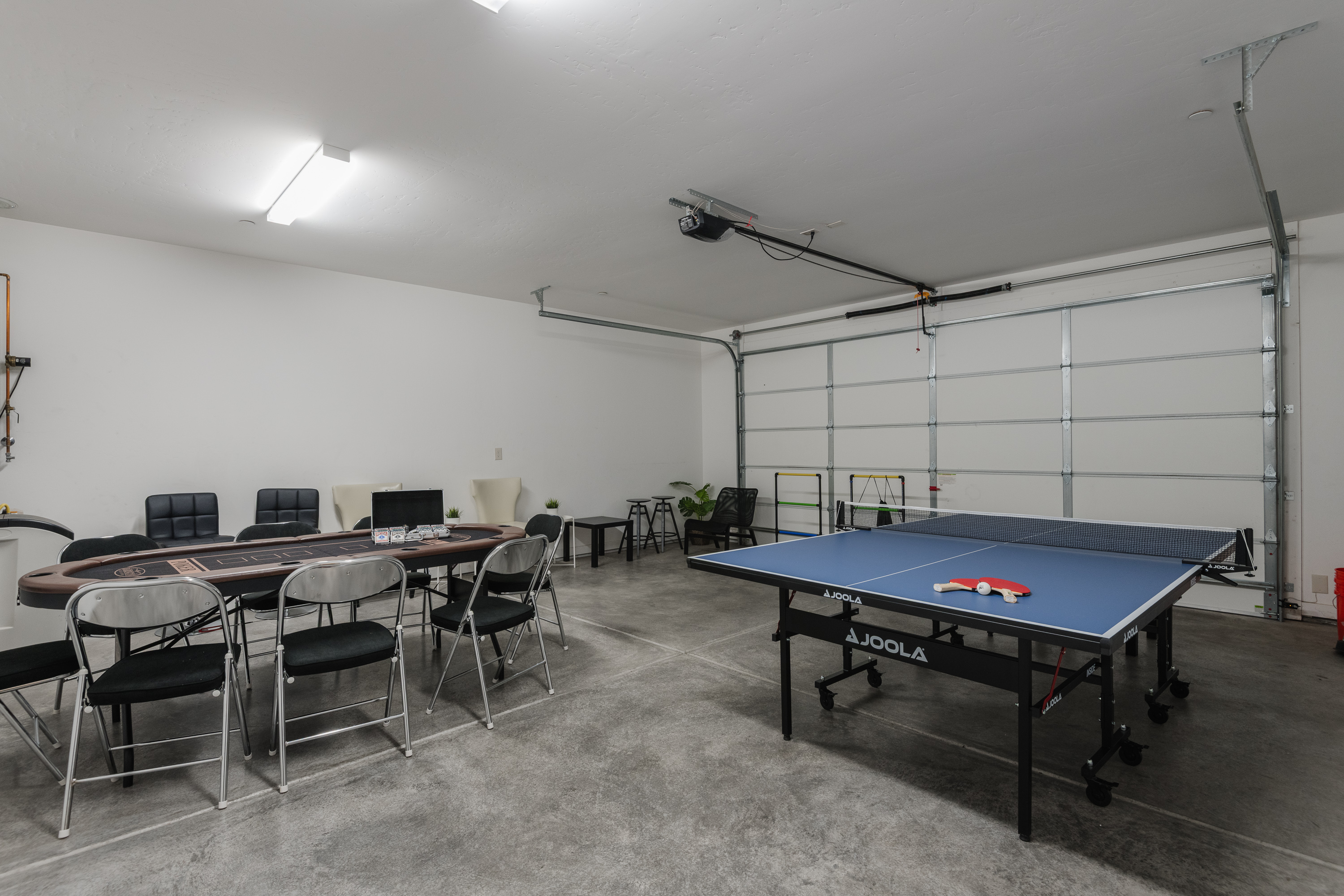 Garage game room with ping pong, poker table, and group seating